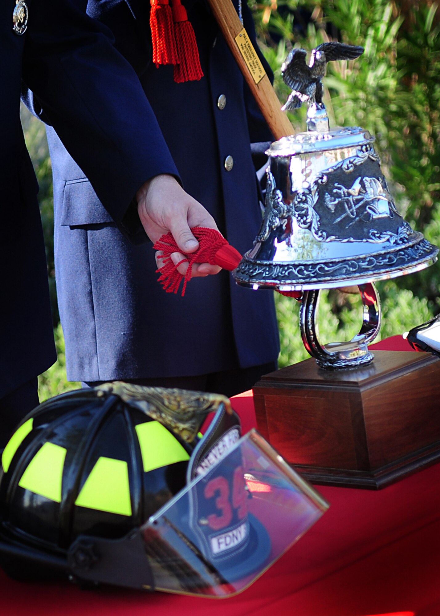 An Aviano Air Base firefighter rings the bell during a 9/11 commemoration ceremony Sept. 9 at the Fire department.  The ringing of the bell is a tradition of the fire service, which reflects respect and honor to those who gave their lives to their duty. (U.S. Air Force photo/Senior Airman Evelyn Chavez)