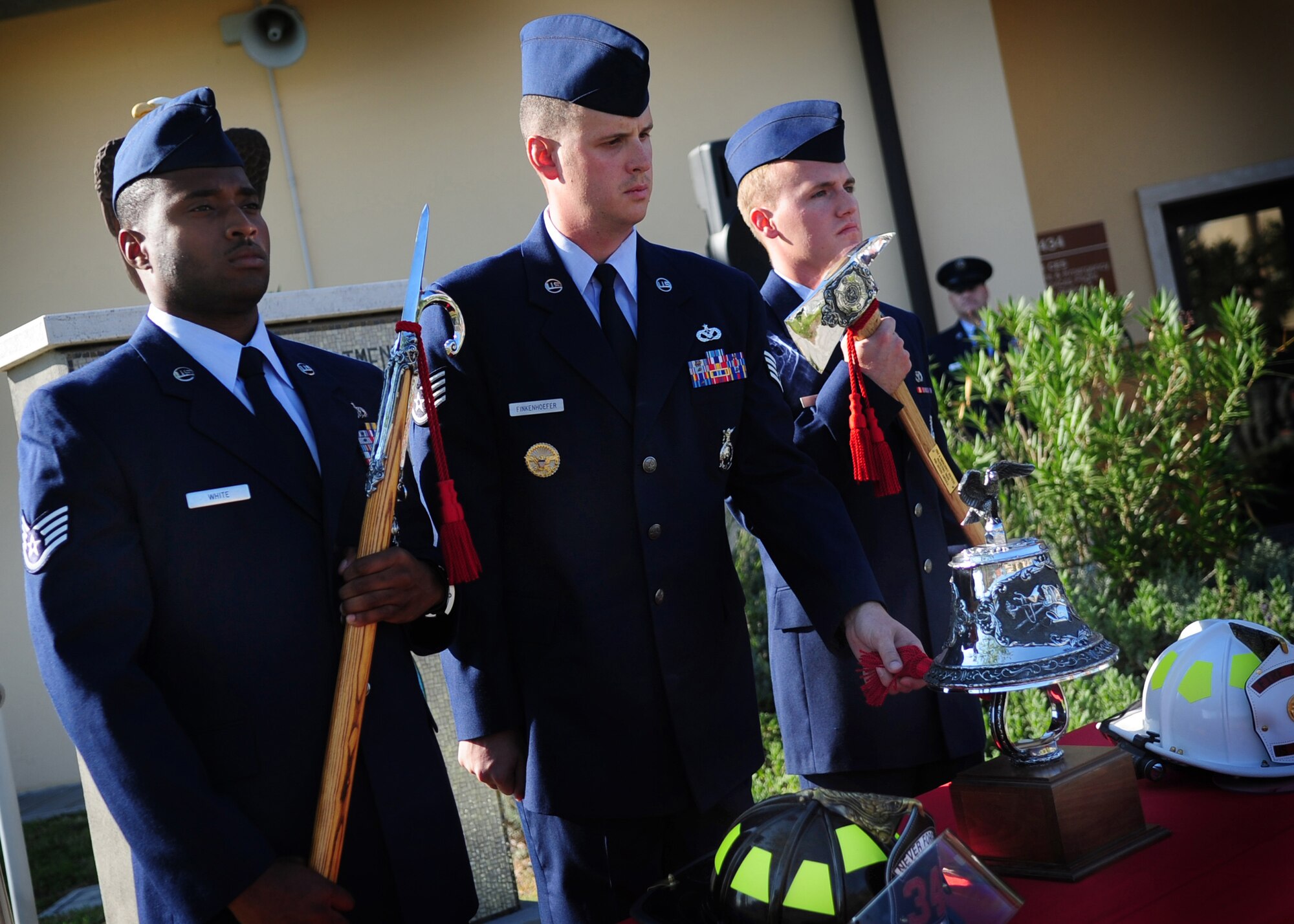 Aviano Air Base firefighters ring the bell during a 9/11 commemoration ceremony Sept. 9 at the fire department in remembrance of the victims lost during the Sept. 11, 2001 tragic event.  The ringing of the bell is a tradition of the fire service, which reflects respect and honor to those who gave their lives to their duty.  (U.S. Air Force photo/Senior Airman Evelyn Chavez)