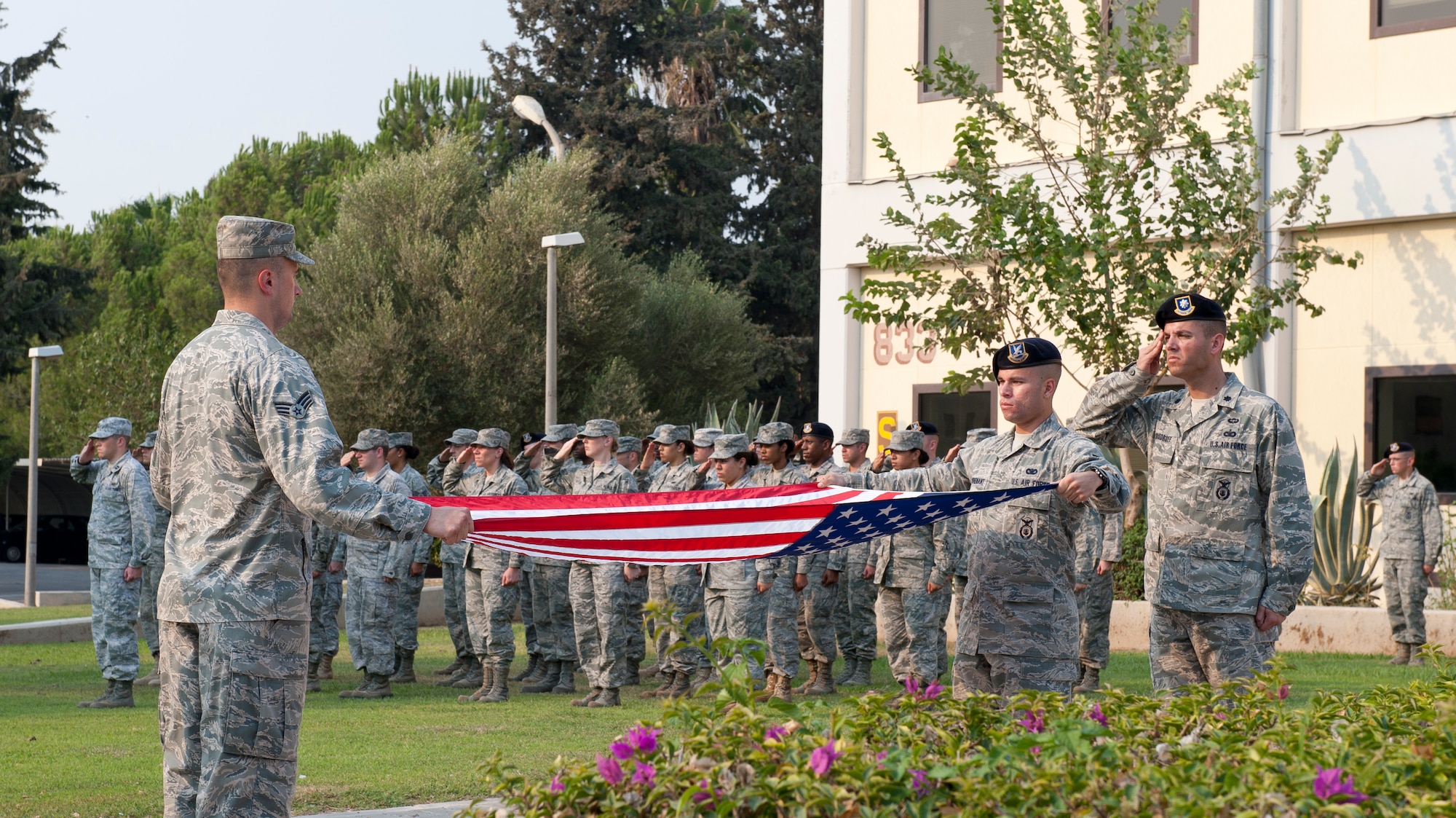 Airmen salute as the American flag is folded during the 9/11 Remembrance Retreat Ceremony Sept. 9, 2011, at Incirlik Air Base, Turkey. The ceremony honored those who lost their lives in the attacks on Sept. 11. (U.S. Air Force photo by Senior Airman Anthony Sanchelli)