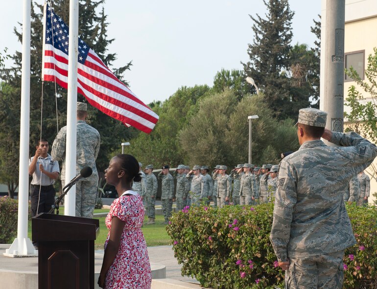 Airmen salute as the American flag is lowered and April Dingle, 39th Medical Support Squadron administrative assistant, sings the American national anthem during the 9/11 Remembrance Retreat Ceremony Sept. 9, 2011, at Incirlik Air Base, Turkey. The ceremony honored those who lost their lives in the attacks on Sept. 11. (U.S. Air Force photo by Senior Airman Anthony Sanchelli)