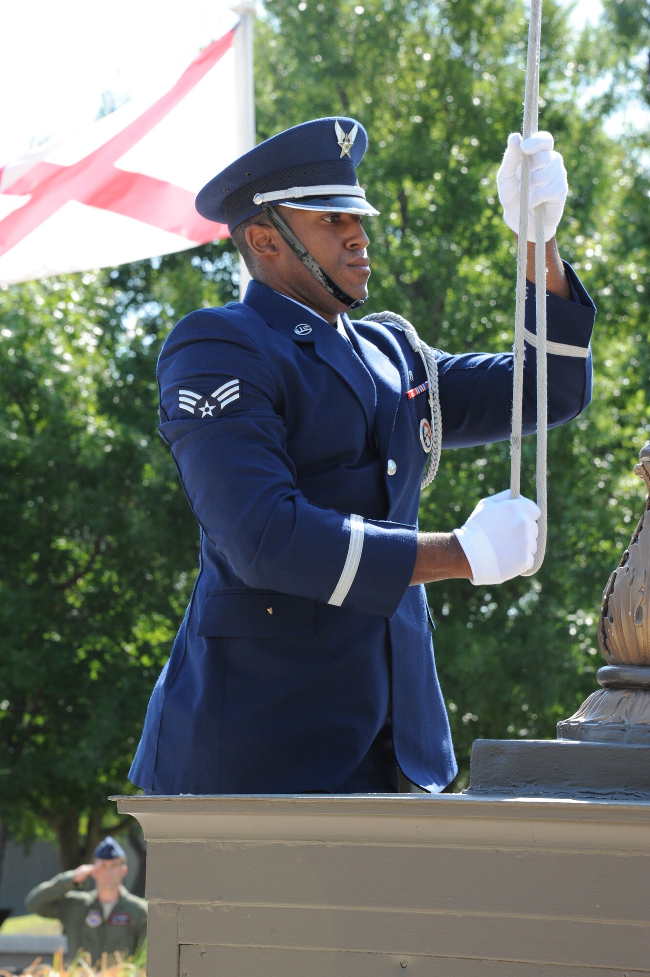 LAUGHLIN AIR FORCE BASE, Texas – Senior Airman Reggie Randolph, 47th Medical Operations Squadron, raises the U.S. flag during Laughlin’s 9/11 Remembrance Ceremony at Heritage Park here Sept. 11 as a flight of Laughlin Airmen salute. Dozens of Laughlin members and Del Rio citizens turned out to honor those who perished 10 years ago on Sept. 11, 2001. (U.S.  Air Force photo/Airman 1st Class Blake Mize) 
