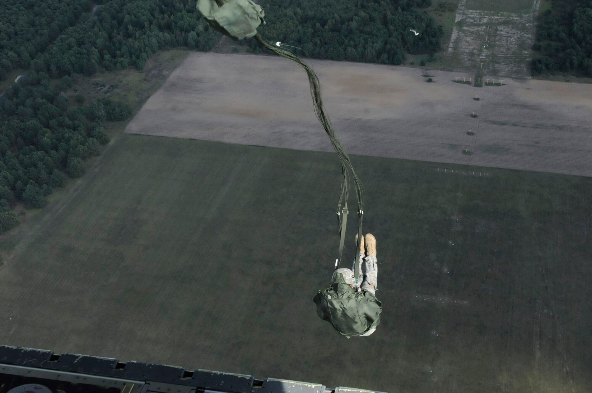 Air Force Staff Sgt. Nickolas Hurst, jumpmaster, 435th Security Forces Squadron, exits a C-130J Super Hercules during a static line jump over the airfield in Powidz, Poland, Sept. 5, 2011. This jump was conducted as part of Operation Screaming Eagle, a 10 day off-station training exercise where members of U.S. military join their Polish counterparts to train together and strengthen partnerships. (U.S. Air Force photo by Staff Sgt. Michael E. Davis)