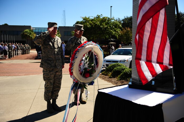 Col. Richard McComb and Chief Master Sgt. Jose LugoSantiago salute after laying a wreath at Joint Base Charleston - Air Base, Sept. 9, during a Retreat ceremony commemorating the 10th anniversary of the 9/11 attacks. During the ceremony, a 9/11 monument was unveiled, a C-17 formation conducted a flyby and a 21-gun salute honored the lives lost during the attack and the ensuing War on Terrorism.  McComb is the Joint Base Charleston commander and LugoSantiago is the 628th ABW command chief.  (U.S. Air Force photo/Airman 1st Class Jodi Martinez) 

