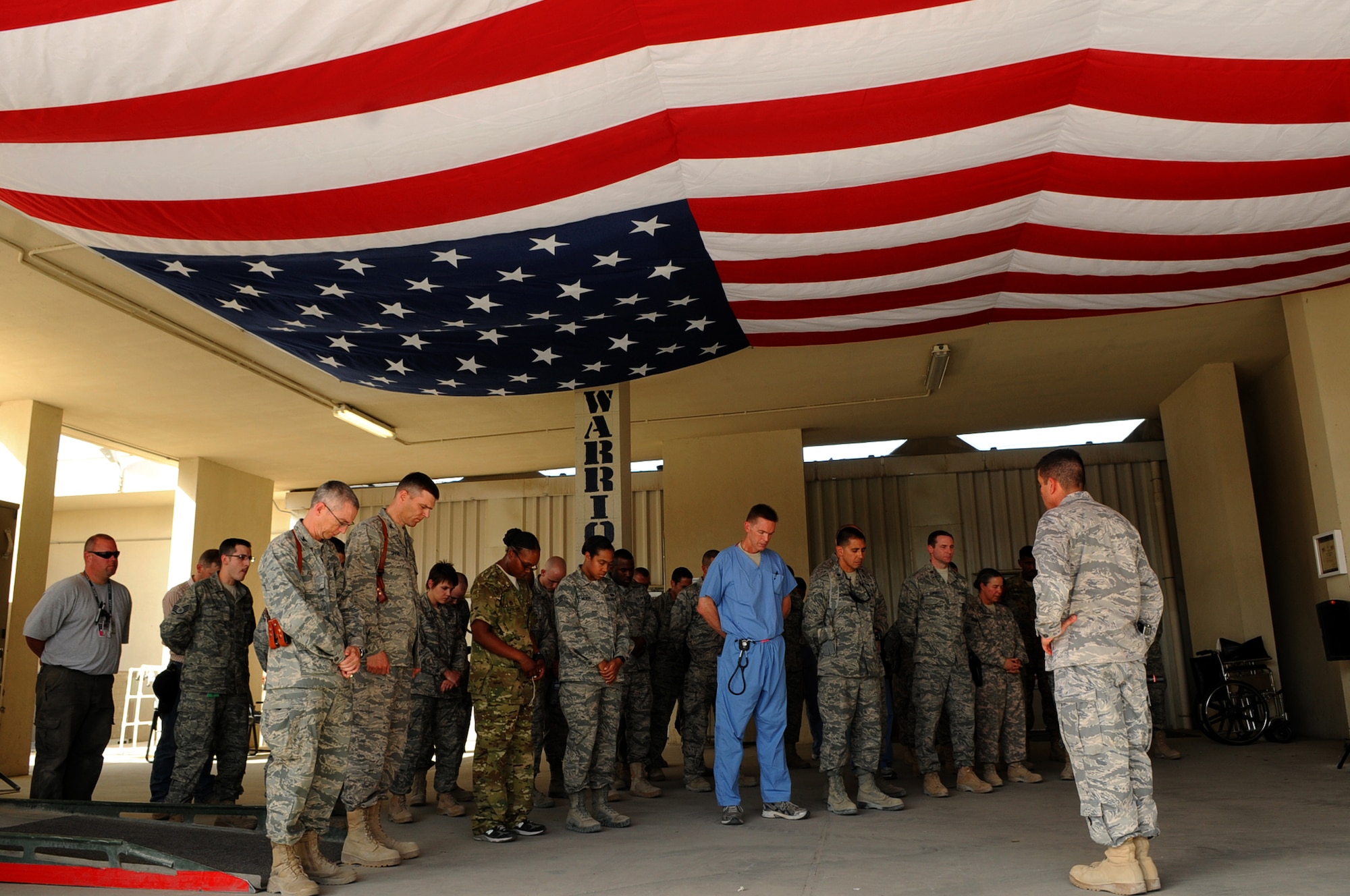 BAGRAM AIRFIELD, Afghanistan -- Bagram community members gather together for a moment of silence during a flag dedication ceremony at the Craig Joint Theatre Hospital here Sept. 11, 2011. The flag, provided by Congressman Don Young, was flown over Washington D.C and was is displayed in the emergency room entrance overhang. The flag will be the first thing injured personnel see when entering through the emergency room. (U.S. Air Force photo/ Senior Airman Krista Rose)