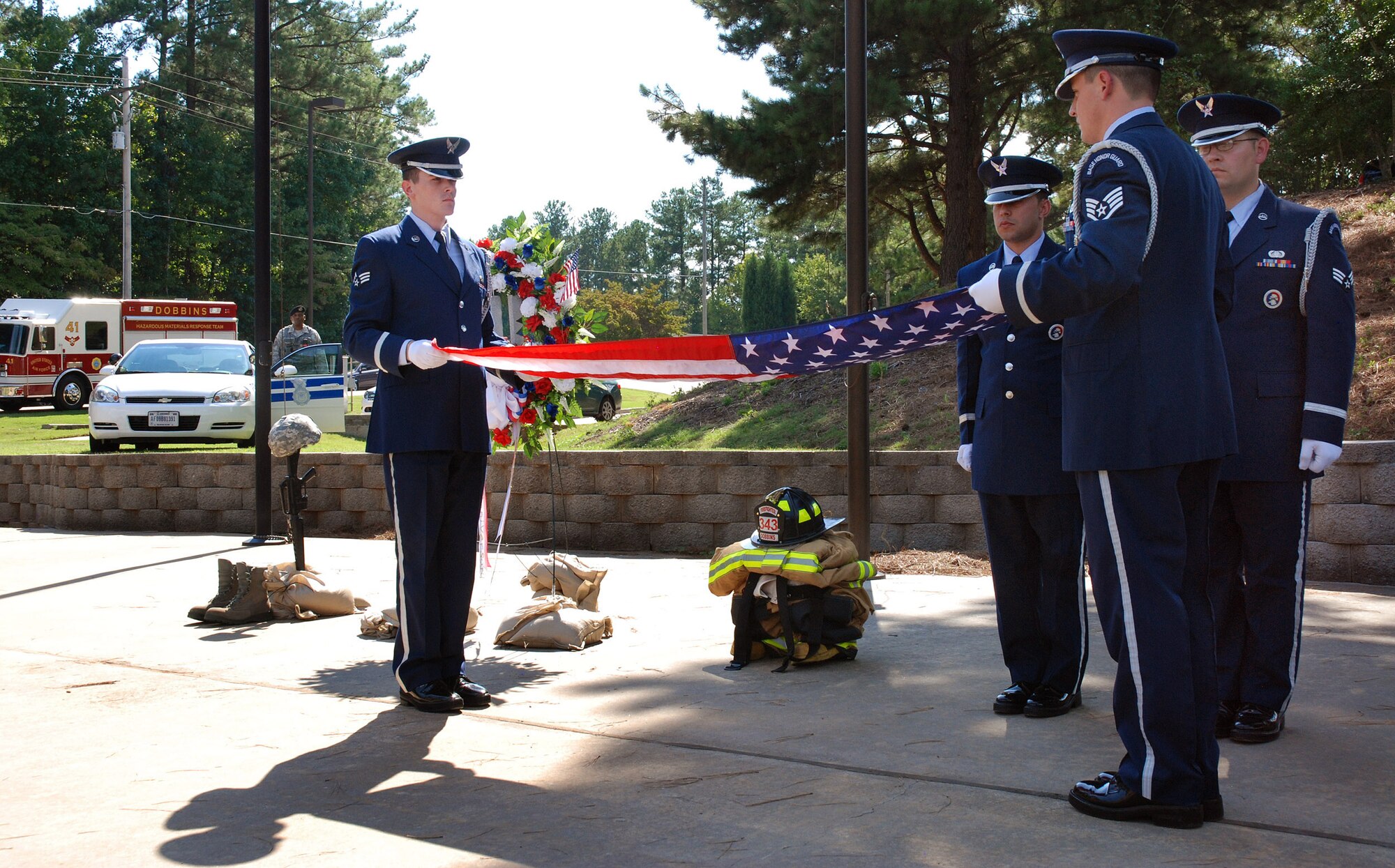 The 94th Airlift Wing Honor Guard flag detail begins to fold the U.S. flag at Dobbins Air Reserve Base during a retreat ceremony to honor the 10th anniversary of the 2001 terrorist attacks, Sept 11.   (U.S. Air Force photo/ Senior Airman Spencer Gallien)