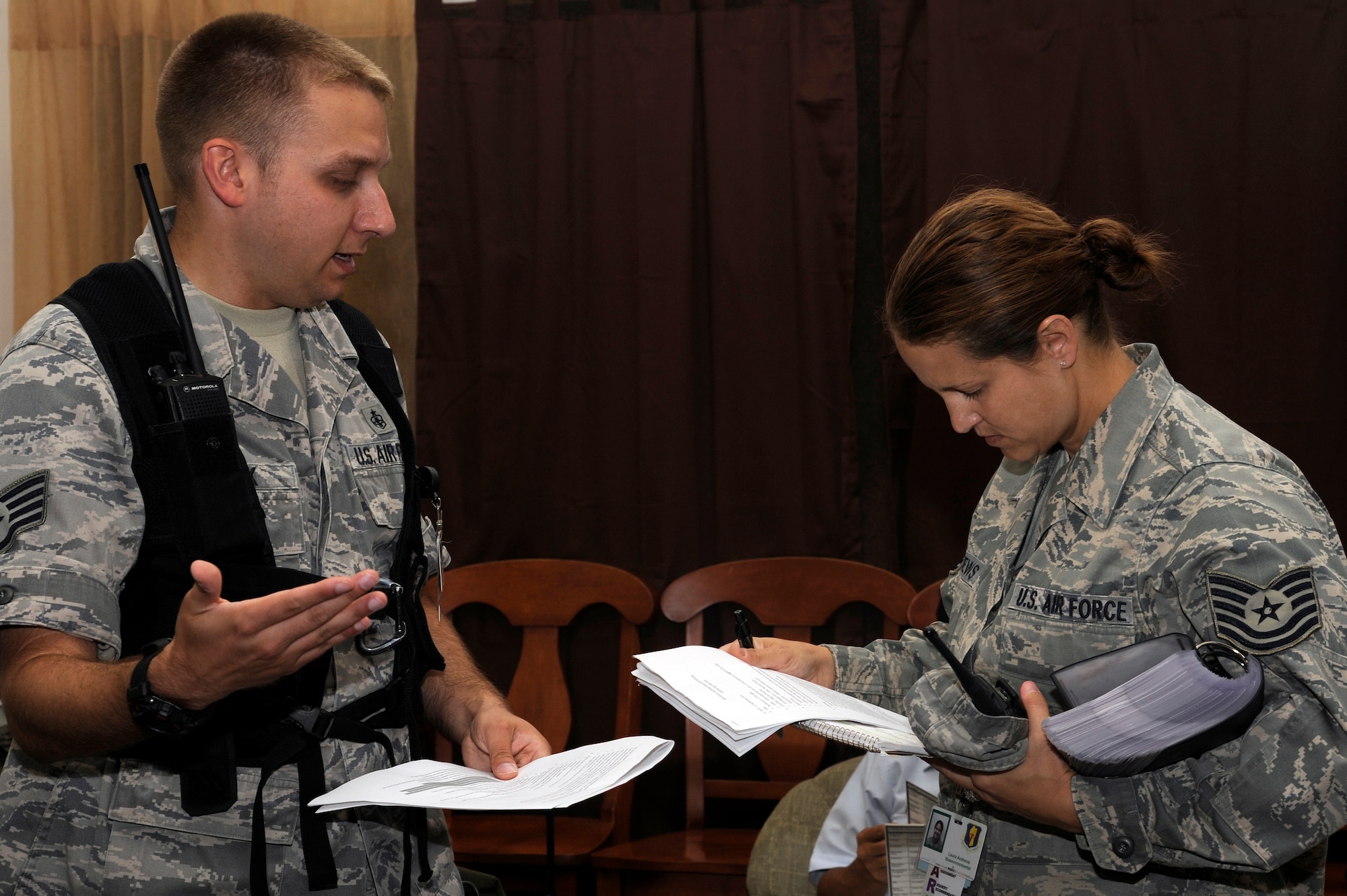 MISAWA AIR BASE, Japan - Staff Sgt. Adam Grosek, left, 35th Aerospace Medicine Squadron, briefs Tech. Sgt. Laura Andrews, 35 AMDS, on the exercise scenario during a biological response exercise at building 99 here Sept. 12. Airmen train to maintain readiness and to ensure they are prepared for any situation that might occur. (U.S. Air Force photo/Tech. Sgt. Marie Brown)