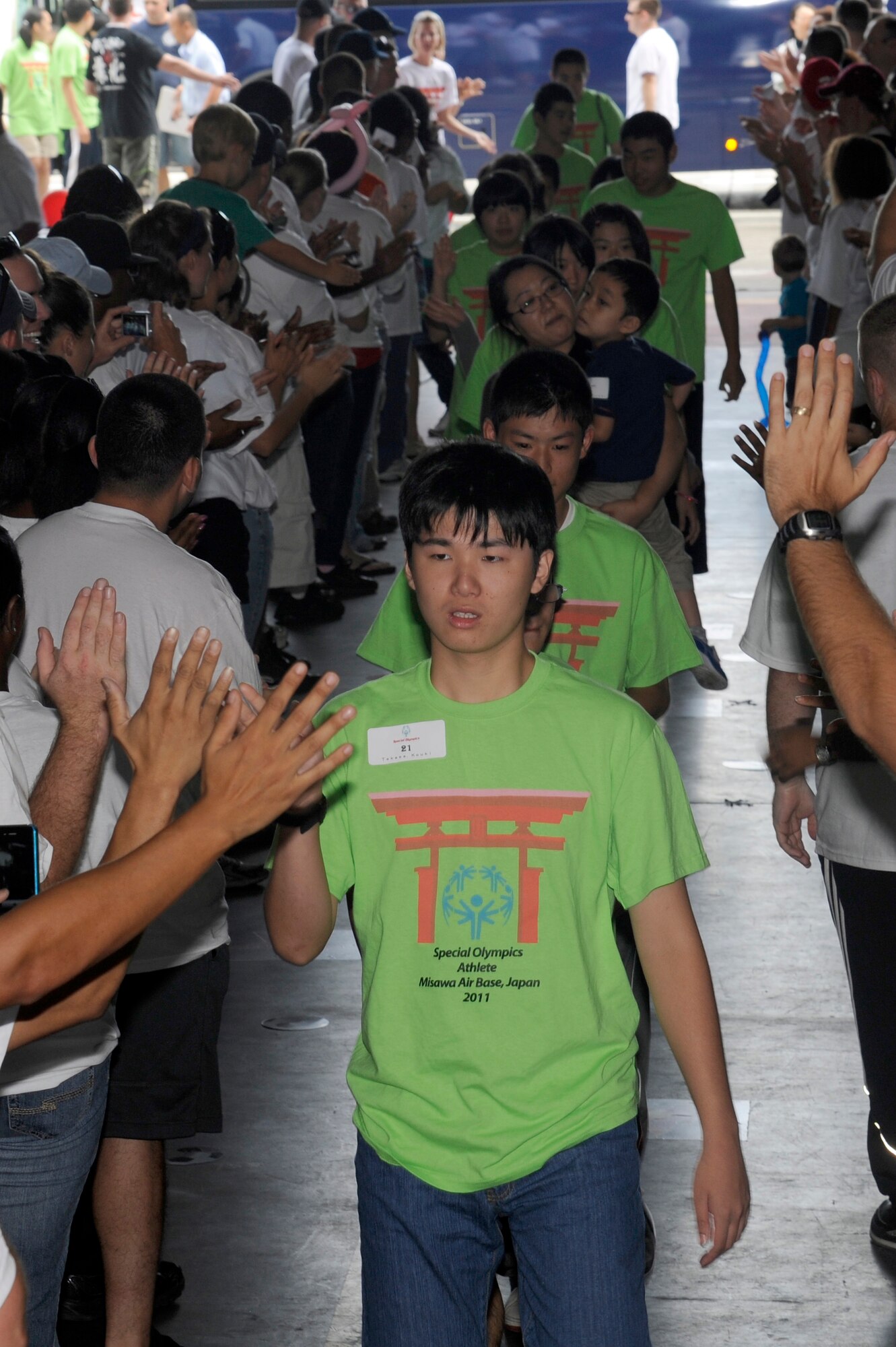 MISAWA AIR BASE, Japan - Special Olympic athletes receive applause and high-fives as they enter Hangar 949 here Sept. 10. Athletes were each paired with two volunteers to help them with the events and cheer them on. (U.S. Air Force photo/Tech. Sgt. Marie Brown)