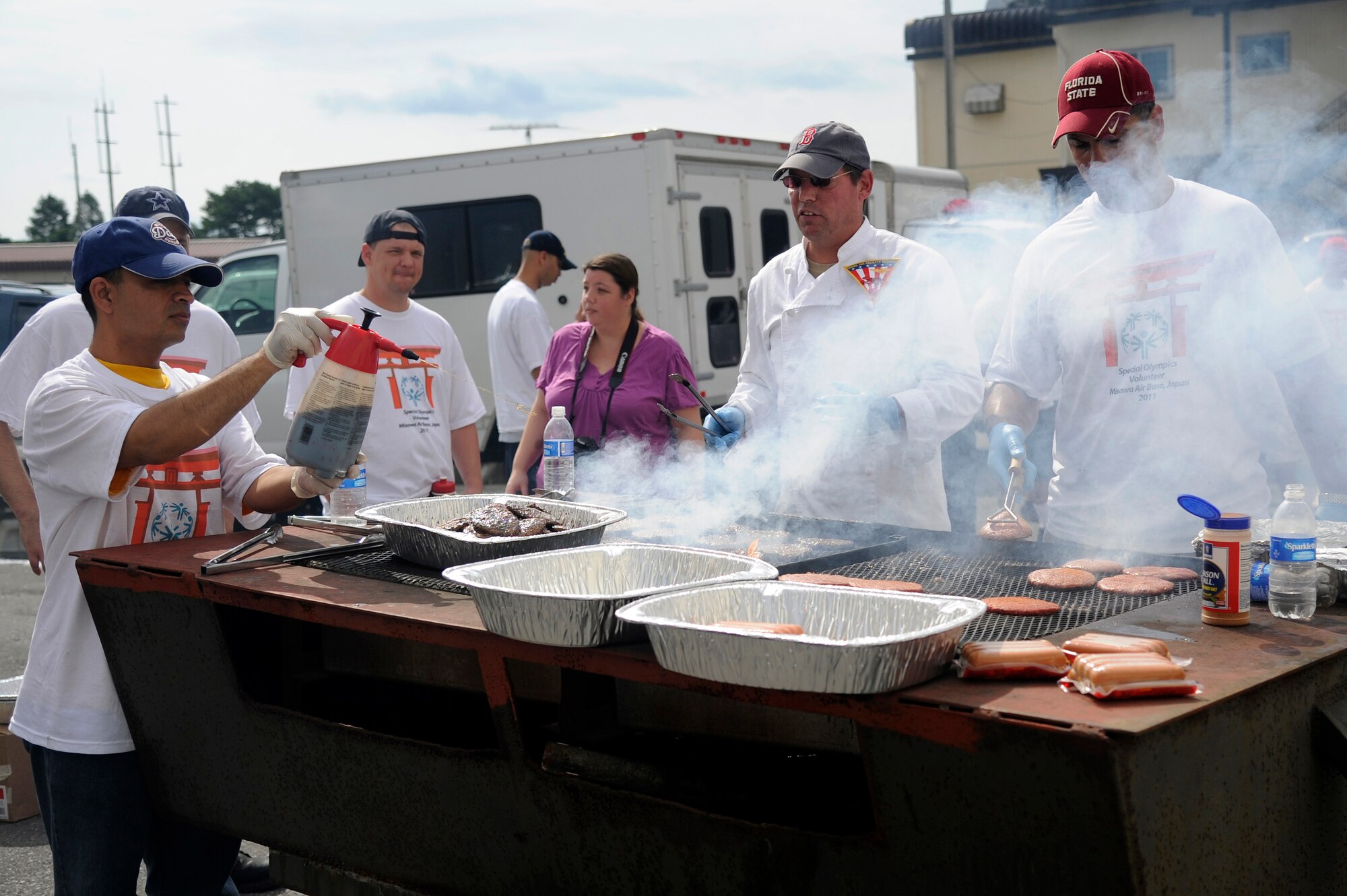 MISAWA AIR BASE, Japan - U.S. Navy personnel grill hamburgers and hot dogs for athletes and volunteers at Hangar 949 during the annual Special Olympics here Sept. 10. The sailors fed approximately 64 athletes and more than 350 volunteers. (U.S. Air Force photo/Tech. Sgt. Marie Brown)