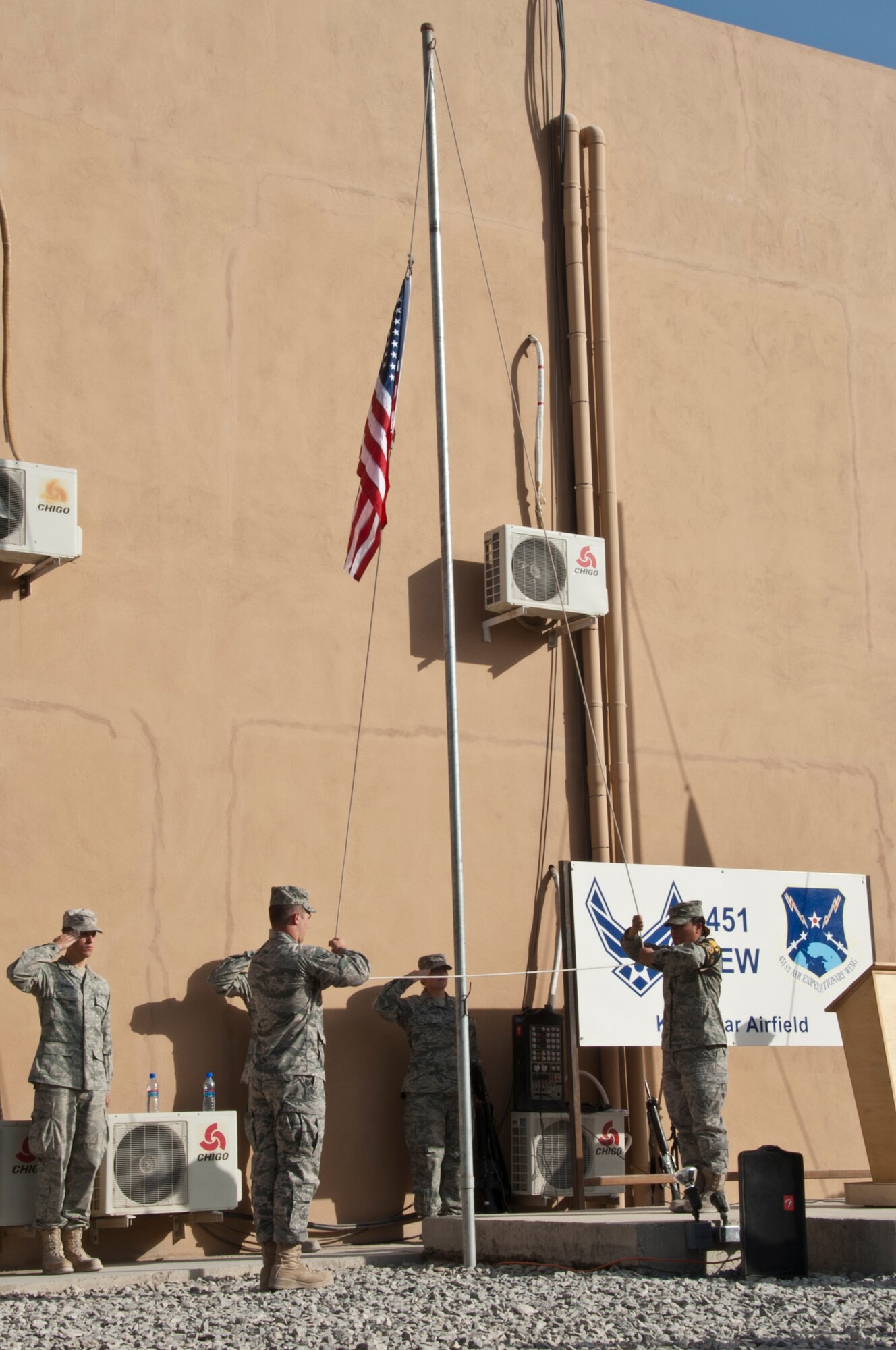 KANDAHAR AIRFIELD, Afghanistan -- Airmen of the Kandahar Airfield Honor Guard lower the flag to half staff during the 9/11 Memorial Ceremony at Camp Losano Sept. 11, 2011. The flag was lowered to half staff to honor those who perished during the 9/11 attacks.  (U.S. Air Force photo by Senior Airman David Carbajal)
