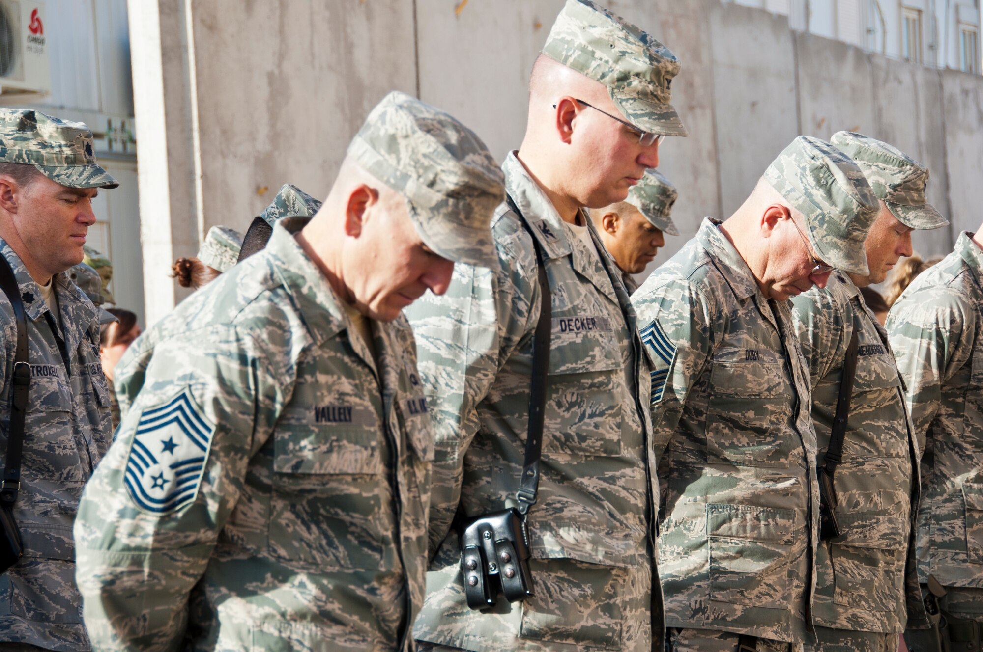 KANDAHAR AIRFIELD, Afghanistan -- Members of the 451st Air Expeditionary Wing bow their heads during the invocation of the 9/11 Memorial Ceremony at Camp Losano Sept. 11, 2011. Airmen assigned to Kandahar Airfield came together on the 10th anniversary to honor those who perished during the 9/11 attacks. (U.S. Air Force photo by Senior Airman David Carbajal)
