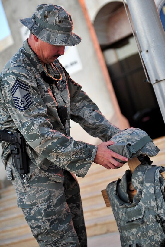 U.S. Air Force Chief Master Sgt. Gary Murphy sets up a display representing fallen security forces, airmen and police officers before a flag-folding ceremony on Sather Air Base, Iraq, Sept. 11, 2011.