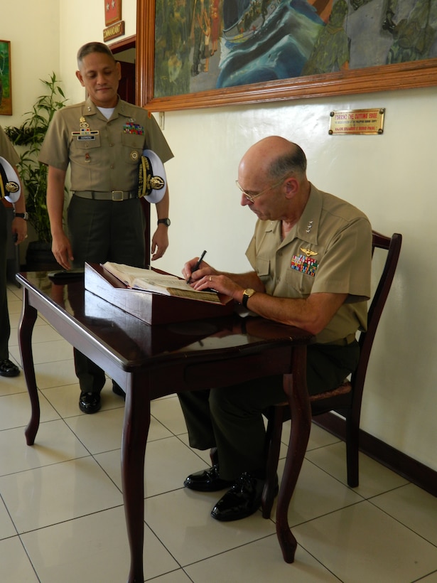 Lt. Gen. Duane D. Thiessen, commander of U.S. Marine Corps Forces, Pacific, signs the guest book as Maj. Gen. Rustico Guerrero, commandant of the Philippine Marine Corps, observes during Thiessen’s visit to the Philippine Marine Corps headquarters, Sept. 14. Thiessen visited the Philippines to meet with the U.S. ambassador, U.S. and Filipino military officials, and component commanders from the Armed Forces of the Philippines.