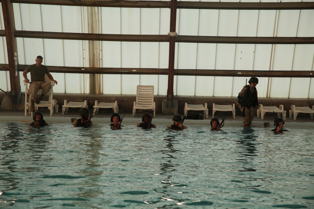 Marines conduct new swim qualification standards and procedures at Cherry Point combat pool Sept. 13. At the basic qualification level the Marines are required to shed their gear, while in the water, in less than 10 seconds.