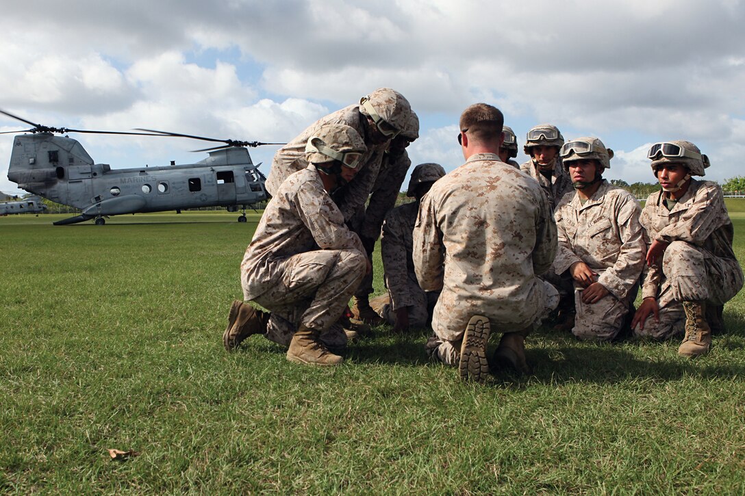 Petty Officer 3rd Class Glenn P. Rians, middle, hospital corpsman, discusses patient care with Marines and sailors with 3rd Medical Battalion during a training exercise on Camp Hansen Sept. 13. The Marines and sailors with 3rd Med. Bn., 3rd Marine Logistics Group, III Marine Expeditionary Force, were familiarized with techniques used to treat causalities while in flight.