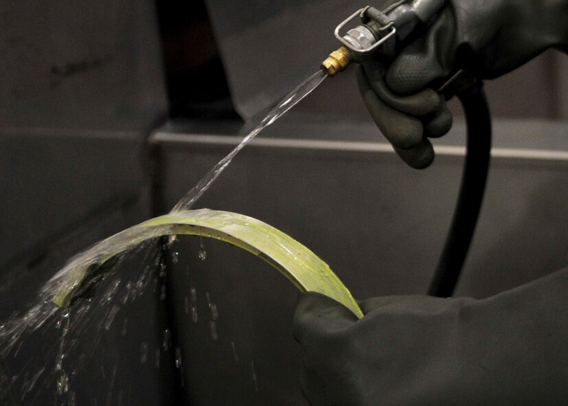 Airman 1st Class Nicole Calungsod, 51st Maintenance Squadron nondestructive inspection technician, rinses penetrant off an aircraft part Sept. 13, 2011. NDI is the examination of aerospace weapon systems components and support equipment for structural integrity using nondestructive inspection methods and fluid analysis.  (U.S. Air Force Photo by/ Senior Airman Adam Grant)