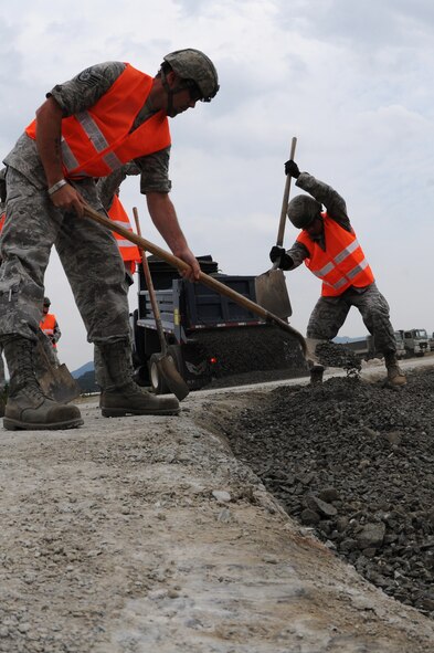 TAEGU AIR BASE, Republic of Korea -- Airmen from the 8th Civil Engineer Squadron, shovel gravel during the 2011 Combined Airfield Damage Repair Exercise here Sept. 8. The purpose of the exercise was to enhance interoperability, evaluate capabilities and strengthen combined relationships between U.S. and Republic of Korea Air Force members. (U.S. Air Force photo/Senior Airman Brittany Y. Bateman)