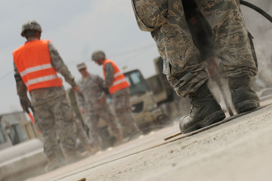 TAEGU AIR BASE, Republic of Korea -- An Airman from the 8th Civil Engineer Squadron, drills a hole in a crater cover mat during the 2011 Combined Airfield Damage Repair Exercise here Sept. 8. The purpose of the exercise was to enhance interoperability, evaluate capabilities and strengthen combined relationships between U.S. and Republic of Korea Air Force members .(U.S. Air Force photo/Senior Airman Brittany Y. Bateman)