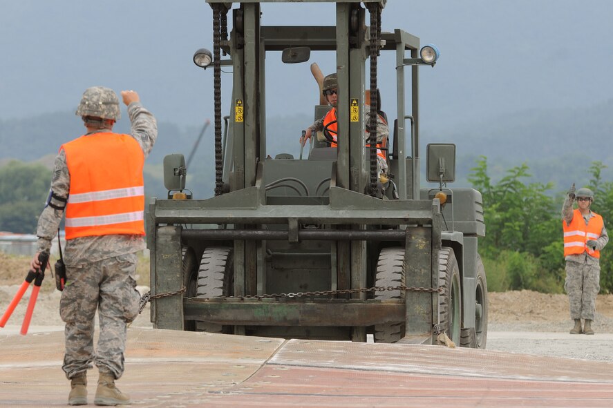 TAEGU AIR BASE, Republic of Korea -- Senior Airman Daniel Brown, 8th Civil Engineer Squadron mat crew, uses a loader to drags a crater cover mat during the 2011 Combined Airfield Damage Repair Exercise here Sept. 8. The purpose of the exercise was to enhance interoperability, evaluate capabilities and strengthen combined relationships between U.S. and Republic of Korea Air Force members. (U.S. Air Force photo/Senior Airman Brittany Y. Bateman)