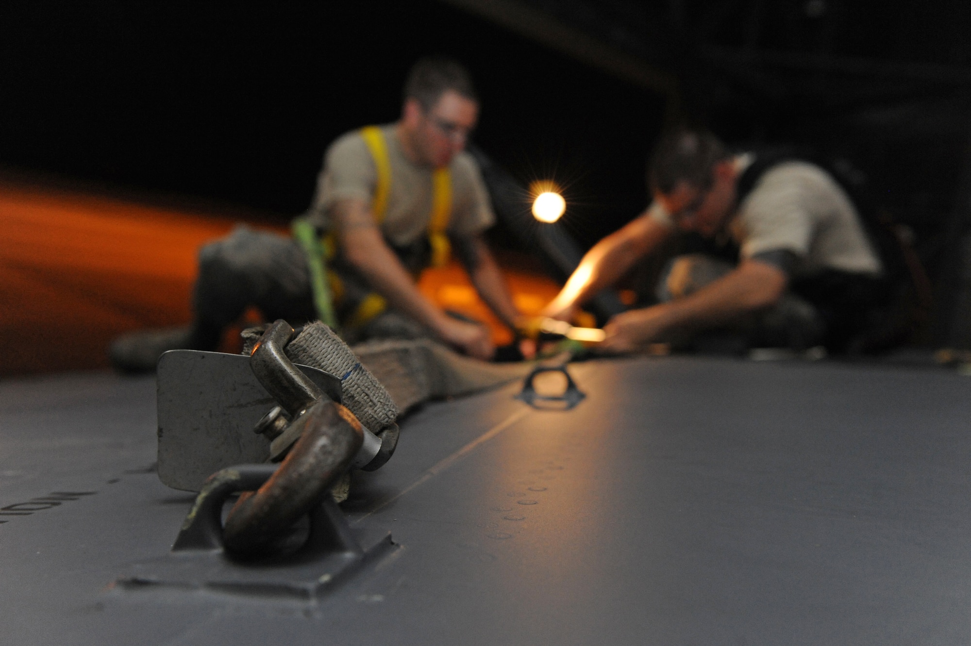 A wing strap connected to a B-52H Stratofortress keeps Staff Sgt. Joshua Partin and Senior Airman Devin Staats-Walker, 2nd Maintenance Squadron Fabrication Flight, from falling off the aircraft on Barksdale Air Force Base, La., Sept. 12. As a safety measure, Airmen are required to wear a harness when working 10 feet or higher of the ground. (U.S. Air Force photo/Airman 1st Class Micaiah Anthony)(RELEASED)