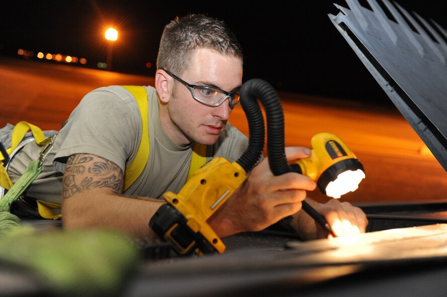 Senior Airman Devin Staats-Walker, 2nd Maintenance Squadron Fabrication Flight, shines a light onto the wing of a B-52H Stratofortress on Barksdale Air Force Base, La., Sept. 12. Airmen from the fabrication flight were sent to repair a broken spoiler on the wing of a B-52H. (U.S. Air Force photo/Airman 1st Class Micaiah Anthony)(RELEASED)