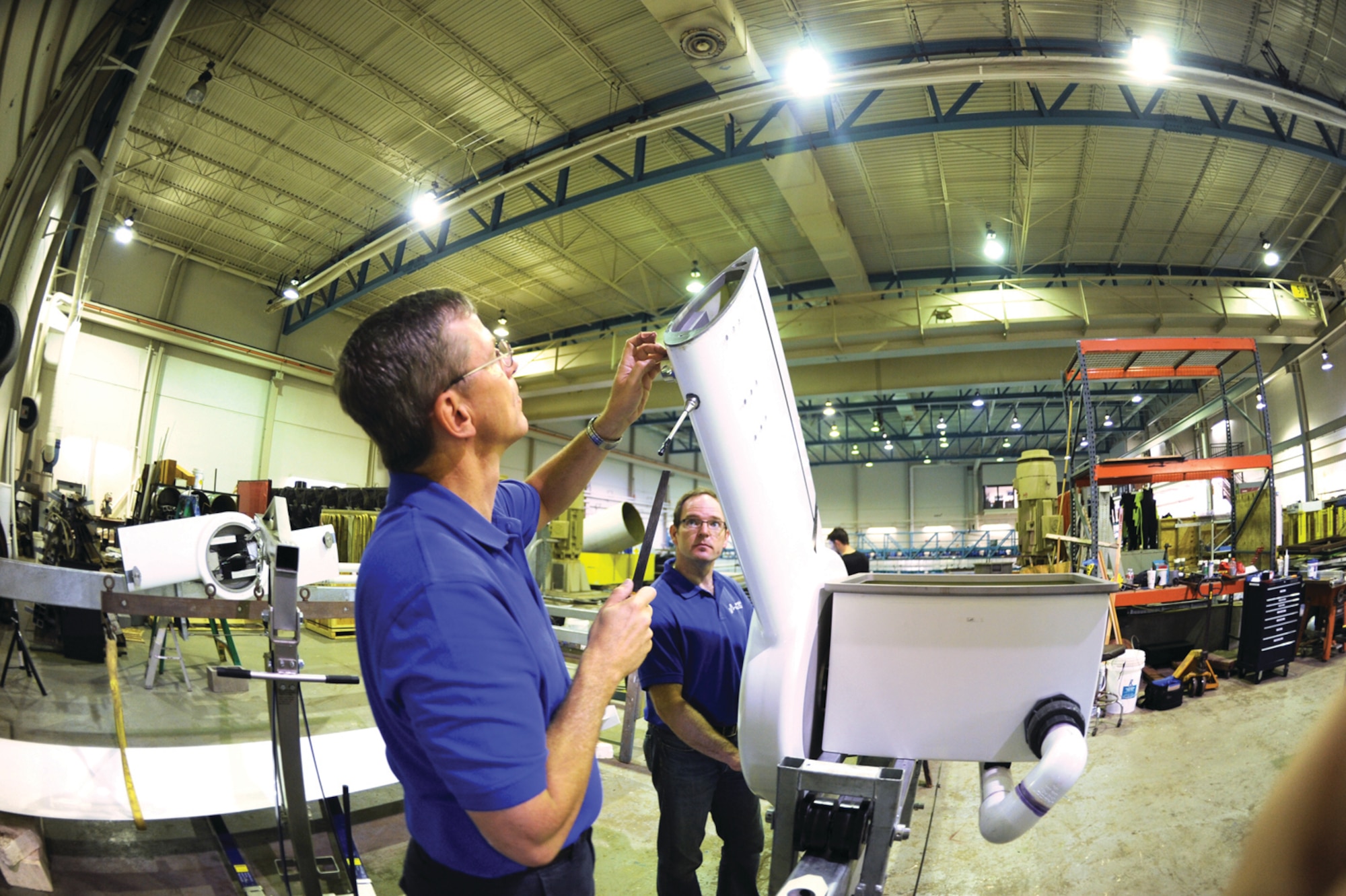 Retired Col. Rob Fredell files a metal socket on the pylon, which will connect 
the blades of the wave energy converter (U.S. Air Force Photo/John Van Winkle)