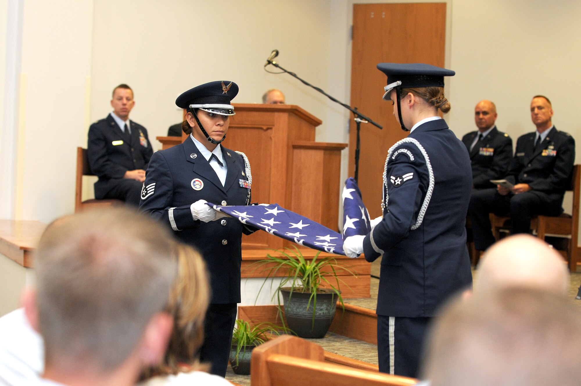 GOODFELLOW AIR FORCE BASE, Texas – (From left:) Honor guard members, Staff Sgt. Charmaine Moss and Airman 1st Class Melissa Murphy, perform a flag folding ceremony during the “9/11 A Decade of Remembrance” memorial service at the Chapel here Sept. 12. The ceremony honored those who died in the Sept. 11, 2001, attacks, and the U.S. casualties from the war on terror.  (U.S. Air Force Photo /Senior Airman Heather L. Rodgers)