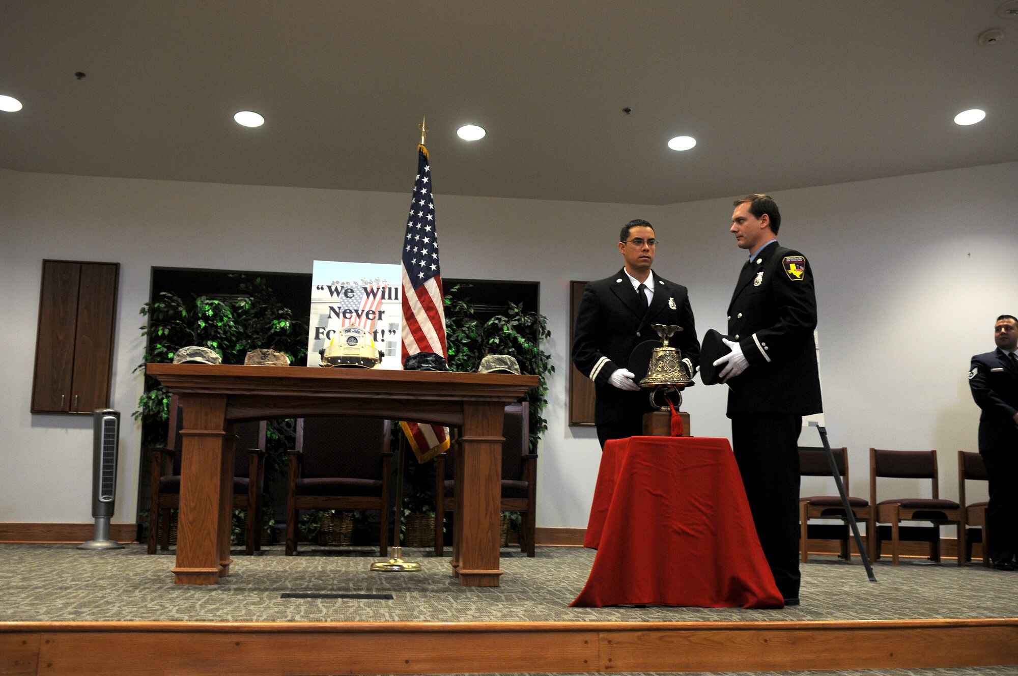 GOODFELLOW AIR FORCE BASE, Texas – (From left:) Goodfellow Fire Department firefighters, Jason Garcia and Alan Hebert, stand as TAPS is played during the "9/11 A Decade of Remembrance" memorial service at the Chapel here Sept. 12. Garcia and Hebert rang the ceremonious bell to honor those who died in the Sept. 11, 2001, attacks, and the U.S. casualties from the war on terror.  (U.S. Air Force Photo /Senior Airman Heather L. Rodgers)