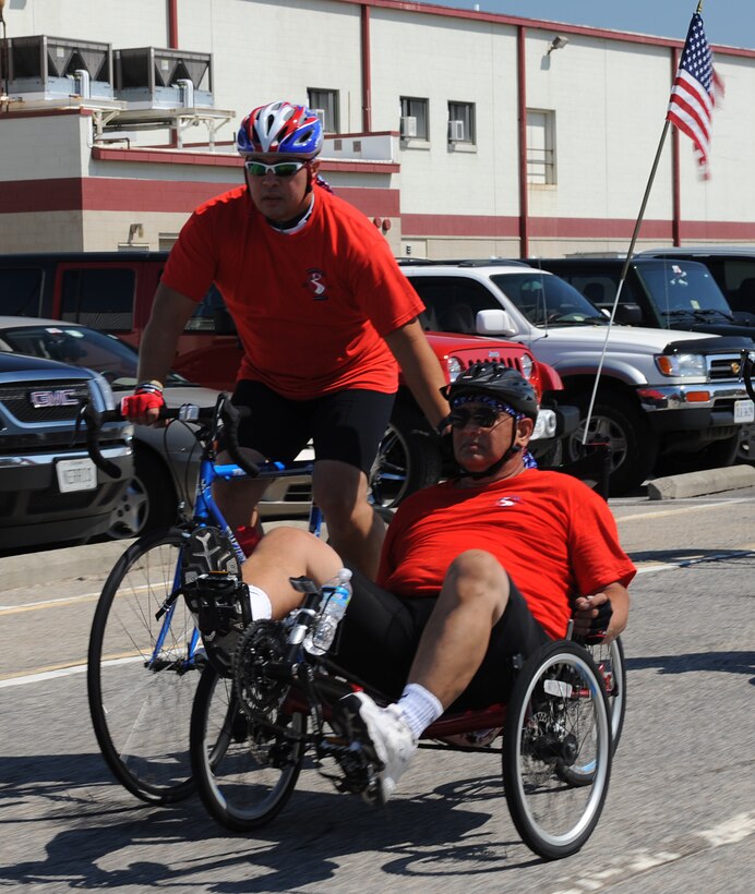 Retired U.S. Marine Corps Cpl. Darrin Snyder assists his father, retired U.S. Navy Petty Officer 1st Class Stanley Snyder, during the Warrior Ride 9/11 Tribute Chesapeake Community Challenge through Naval Station Norfolk, Va., Sept. 9, 2011. Riders from all branches of the military and their families participated in the 46 mile ride through Norfolk and Chesapeake. (U.S. Air Force photo by Airman 1st Class Teresa Cleveland/Released)
