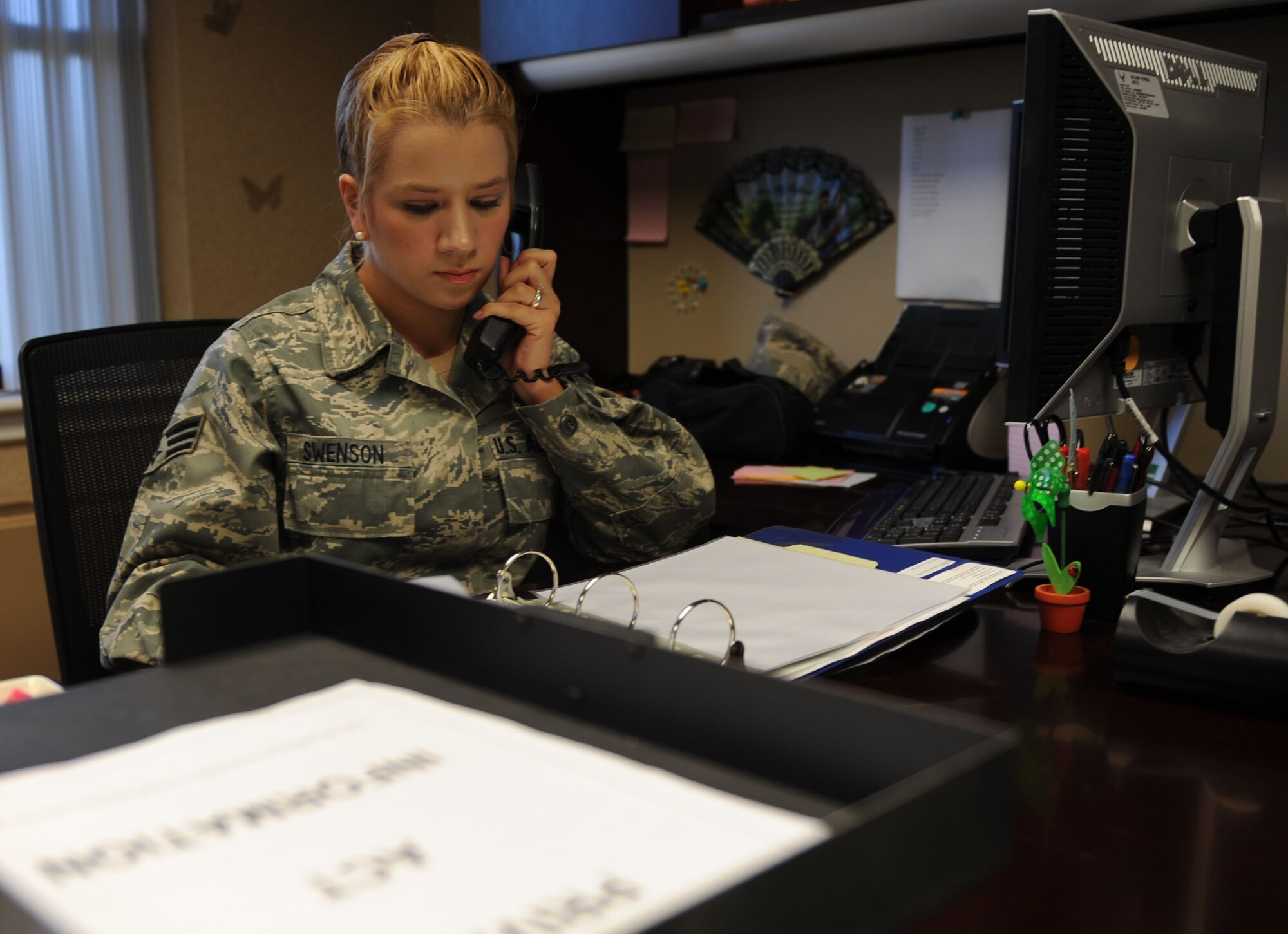 Senior Airman Kaelah Swenson, a 19th Operations Group knowledge operations management information assurance officer, calls in a trouble ticket, Sept. 12, 2011, at Little Rock Air Force Base, Ark. The Spencer, Mass., native was key in ensuring continuous communication by submitting more than 70 trouble tickets during the office’s move. (U.S. Air Force photo by Senior Airman Caleb Pierce)