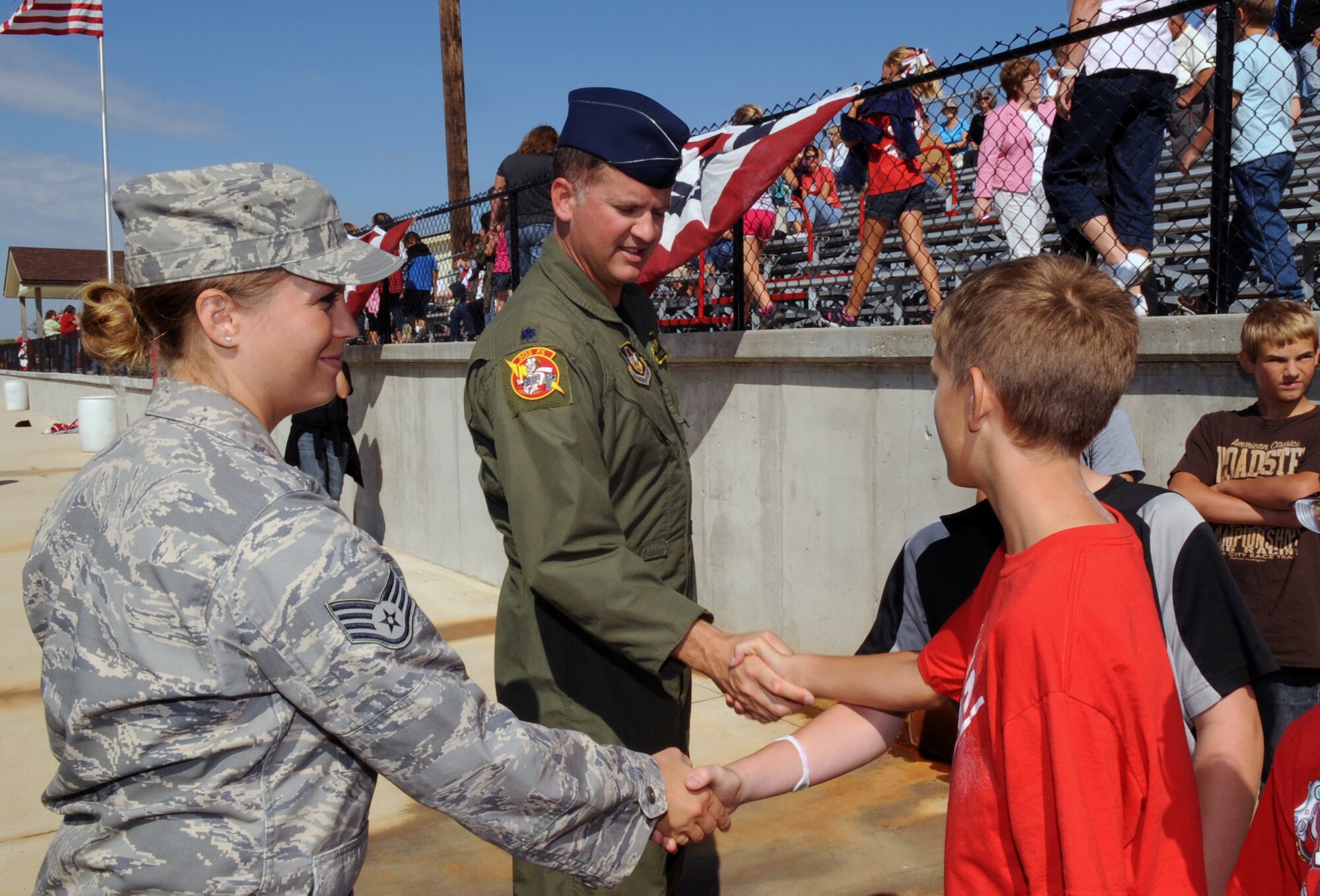 Staff Sgt. Danielle Wolf, 442nd Fighter Wing Public Affairs specialist, and Lt. Col. Preston McConnell, 303rd Fighter Squadron A-10 Thunderbolt II pilot, shake hands with Lincoln High School (Lincoln, Mo.) students during a 9/11 remembrance ceremony, Sept. 9, 2011. During the assembly, McConnell and Wolf spoke about freedom and remembering 9/11 to nearly 500 students, administrators and local community members. The 442nd FW is an Air Force Reserve unit at Whiteman. (U.S. Air Force photo/ Senior Airman Wesley Wright)