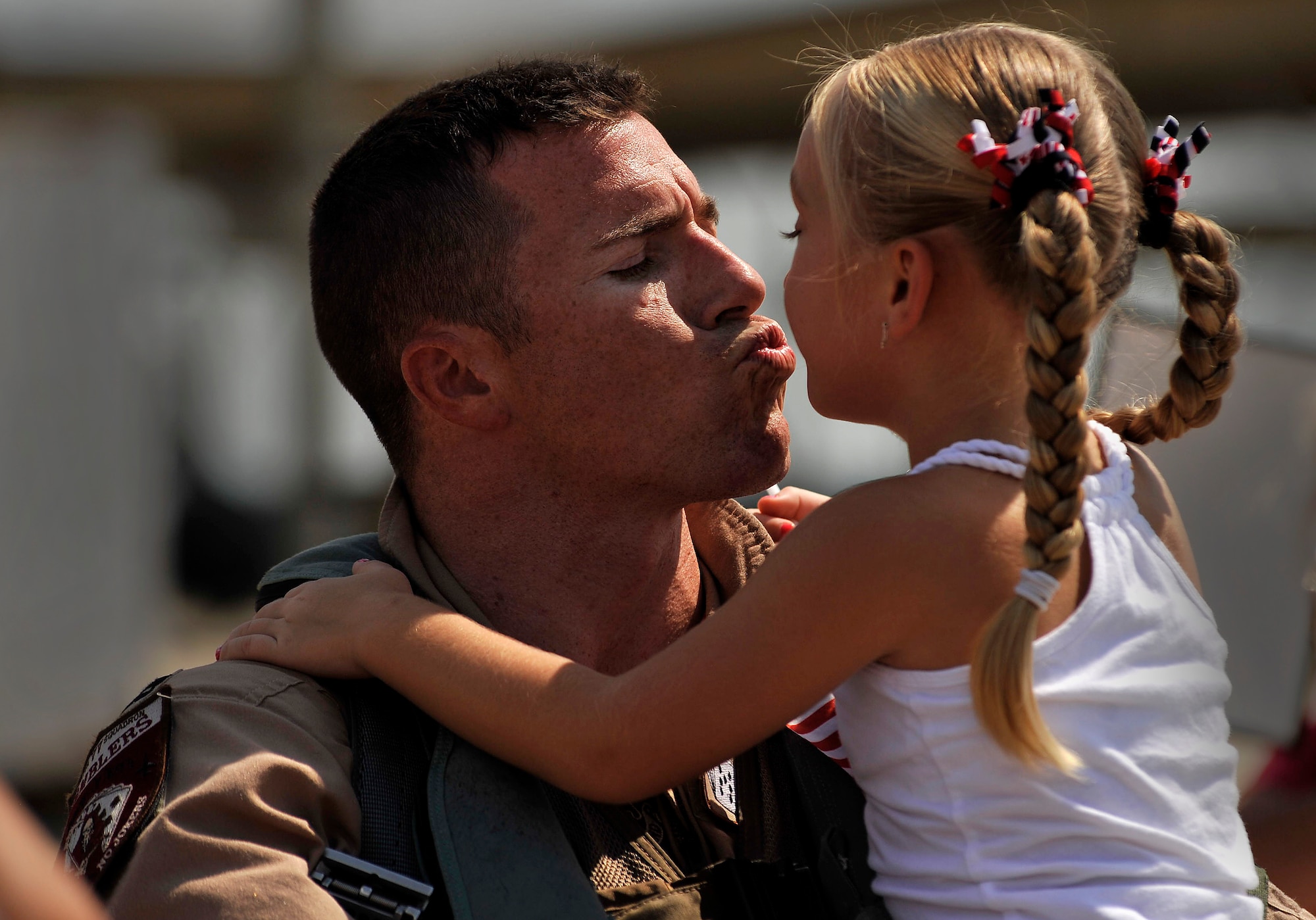 U.S. Air Force Capt. Adam Thornton, 77th Fighter Squadron F-16 Fighting Falcon pilot, gets a welcome home kiss from his daughter after returning from a five month deployment in support of Operation Unified Protector, Sept. 12, 2011, Shaw Air Force Base, S.C. The mission of the 77th FS pilots was to provide air suppression and destruction of enemy defenses. (U.S. Air Force photo by Senior Airman Kenny Holston/Released)


