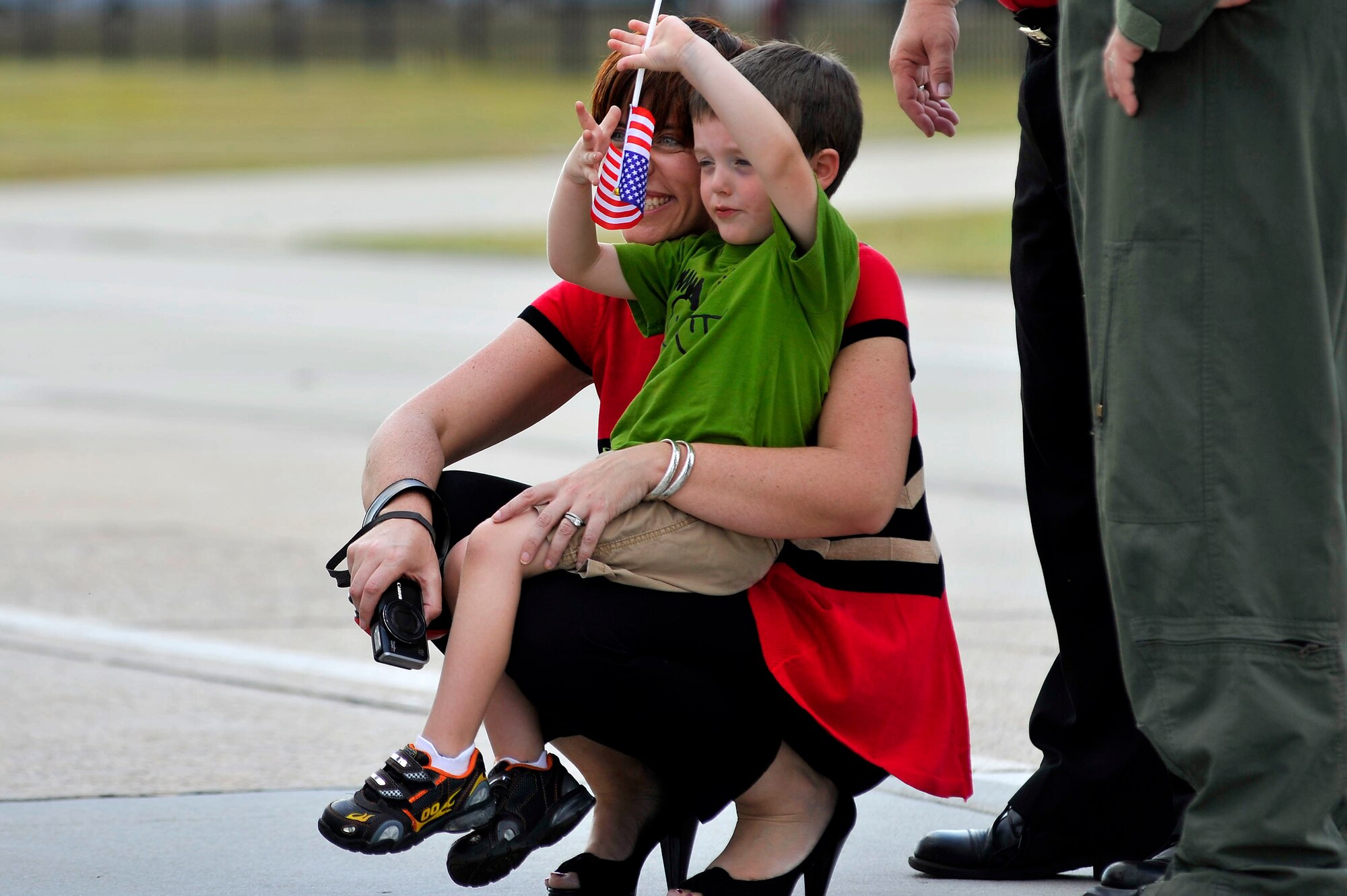 Jenna Nettles and Caden Nettles, wife and son of Maj. Geoffrey Nettles, 77th Fighter Squadron assistant director of operations, wait on the Shaw Air Force Base, S.C., flight line to welcome back 77th FS pilots from a five month deployment in support of Operation Unified Protector, Sept. 12, 2011. (U.S. Air Force photo by Senior Airman Kenny Holston/Released)


