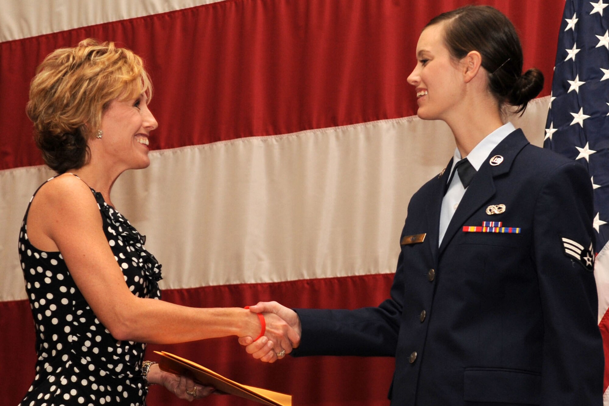 Kara Lowrie, representing Acadiana Mortgage, presents Senior Airman Cassi Heyl with a gift during the Reserve Awards Ceremony at Barksdale Air Force Base, La., Sept. 11, 2011. Heyl is assigned to the 307th Bomb Wing and was selected as Airman of the Quarter for the period covering April to June 2011. (U.S. Air Force photo by Master Sgt. Greg Steele/Released)

