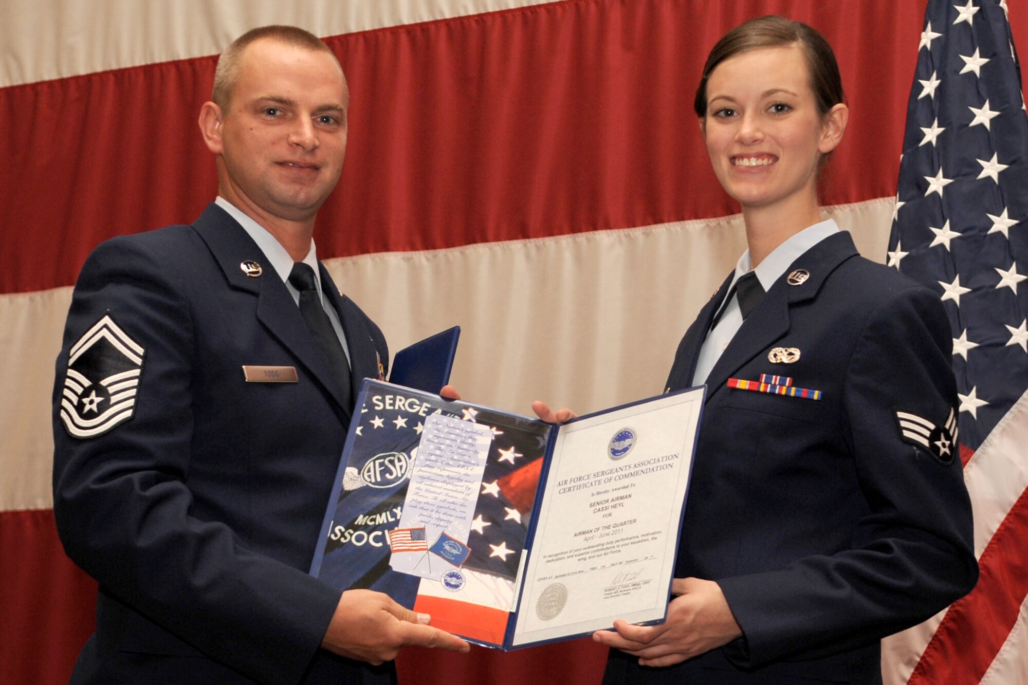 U.S. Air Force Senior Master Sgt. Robert Todd, representing the Air Force Sergeants Association, presents Senior Airman Cassi Heyl with a certificate of commendation during the Reserve Awards Ceremony at Barksdale Air Force Base, La., Sept. 11, 2011. Heyl is assigned to the 307th Bomb Wing and was selected as Airman of the Quarter for the period covering April to June 2011. (U.S. Air Force photo by Master Sgt. Greg Steele/Released)