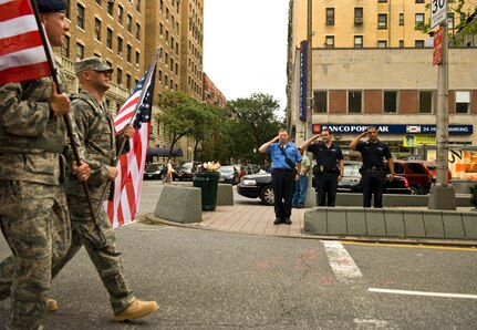 Members of the New York Fire Dept. salute U.S. Air Force Security Forces airman as the march down Broadway Ave. en route to Times Square, Sept. 10 during the Security Forces 9/11 Ruck to Remember. (U.S. Air Force photo/Tech. Sgt. Bennie J. Davis III)
