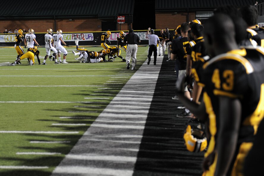 Valdosta High School (VHS) football team members watch as fellow teammates make a defensive stop, during a game against Lincoln High School (LHS) at Cleveland Field, Valdosta, Ga., Sept. 9, 2011.VHS defeated LHS with a final score of 10-7, their current record is 3-0 for the season. (U.S. Air Force photo by Senior Airman Ciara Wymbs/Released