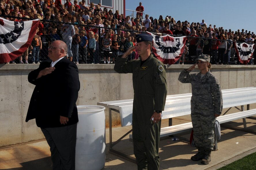 Mr. Ronald Griffith, lead pastor of First Baptist Church, Lincoln, Mo., Lt. Col. Preston McConnell, 303rd Fighter Squadron A-10 Thunderbolt II pilot, and Staff Sgt. Danielle Wolf, 442nd Fighter Wing Public Affairs specialist, both of Whiteman Air Force Base, Mo., pay tribute to the American flag during the national anthem during a Lincoln High School assembly, Sept. 9, 2011. During the assembly, McConnell and Wolf spoke about freedom and remembering 9/11 to nearly 500 students, administrators and local community members. The 442nd FW is an Air Force Reserve unit at Whiteman. (U.S. Air Force photo/ Senior Airman Wesley Wright)