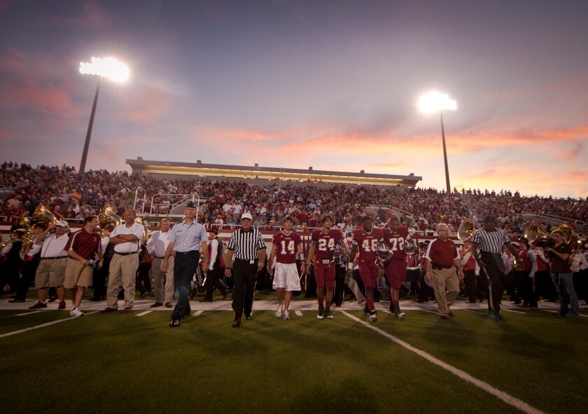 Col. Billy Thompson, 23rd Wing commander, referees and players from Lowndes High School walk to the center of the field for the coin toss before the start of a football game between the Lowndes High-School Vikings and Tallahassee Leon Lions at Martin Stadium, Valdosta, Ga., Sept. 9, 2011. Martin Stadium is named to honor former Lowndes County Schools Superintendent Sonny Martin, who served 20 years as the Superintendent of the Lowndes County School System. (U.S. Air Force photo by Airman 1st Class Joshua Green/Released)

