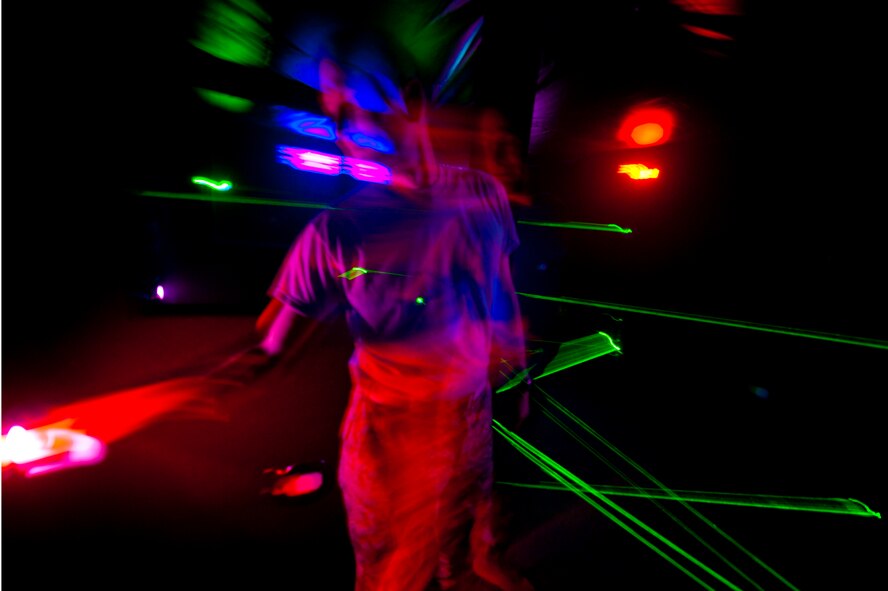 U.S. Air Force Col. Billy Thompson, commander, 23rd Wing, reaches for the exit switch after navigating a laser maze at the grand opening of "The Spot" on Moody Air Force Base, Ga., Sept. 9, 2011. The laser maze scores player's on their ability to quickly navigate an area without touching any of the random generated lasers. Each time a laser is touched, points will be docked from the players overall score.   (U.S. Air Force photo by Staff Sgt. Joshua J. Garcia/Released)