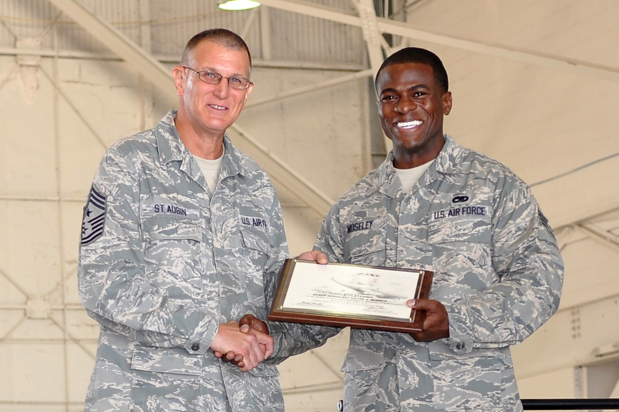 Command Chief Master Sgt. Keith St. Aubin of the 307th Bomb Wing and Staff Sgt. Keyne J. Moseley are all smiles during a recent non-commissioned officer induction ceremony at Barksdale Air Force Base, La., Sept. 10, 2011. St. Aubin presented plaques to several newly promoted non-commissioned officers during the ceremony.  During a speech to the new NCOs, St. Aubin emphasized the importance of their new leadership roles and the importance of staying positive. (U.S. Air Force Photo by Staff Sgt. Ted Daigle/Released) 
