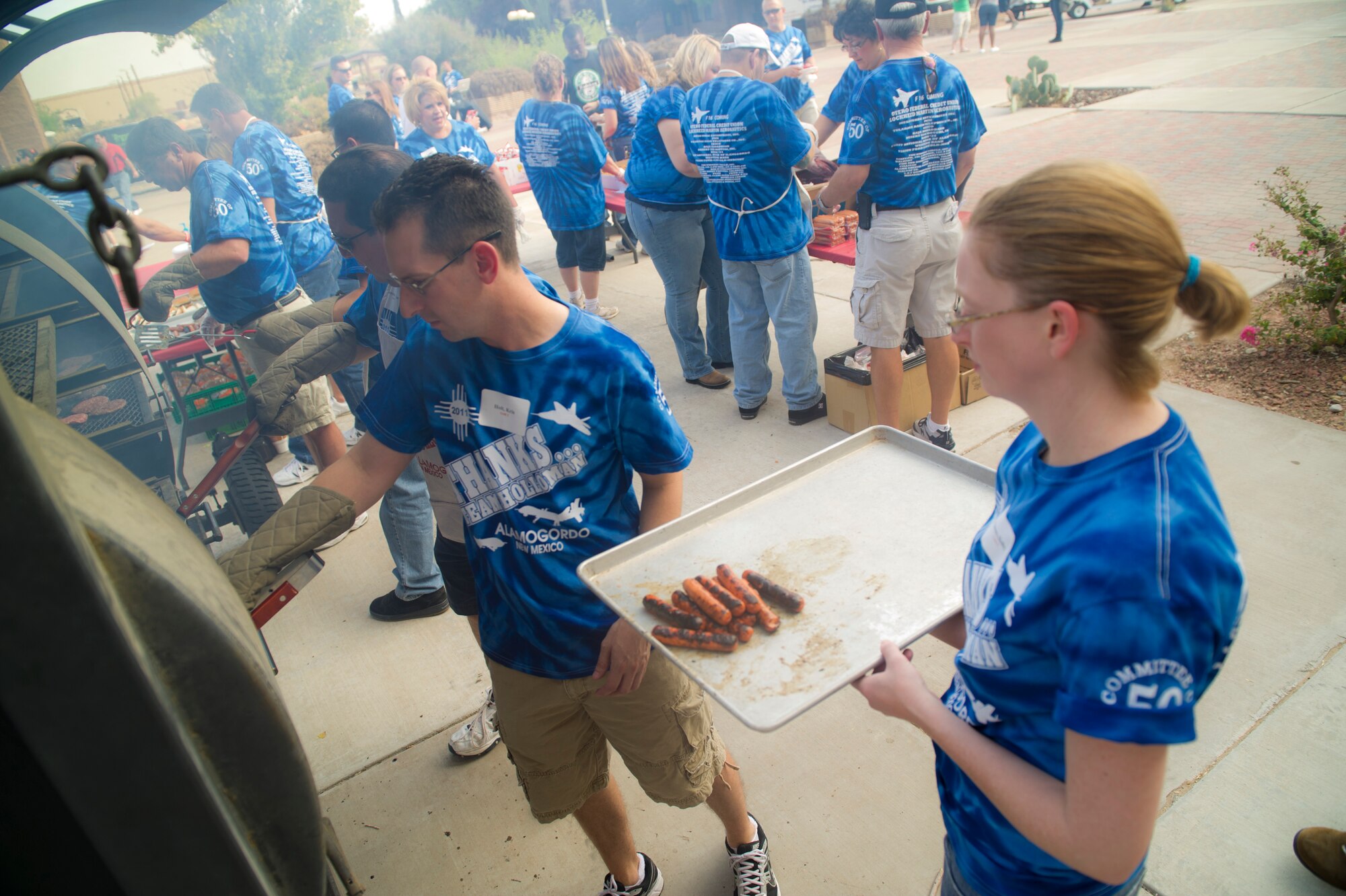 HOLLOMAN AIR FORCE BASE, N.M. -- Volunteers from the local community cook hot dogs and hamburgers in the dormitory courtyard Sept. 9, 2011, during this year’s “Thanks Team Holloman.” This annual event  is supported by the Alamogordo community to show their appreciation for Team Holloman. (U.S. Air Force photo by Airman 1st Class Joshua Turner/Released) 