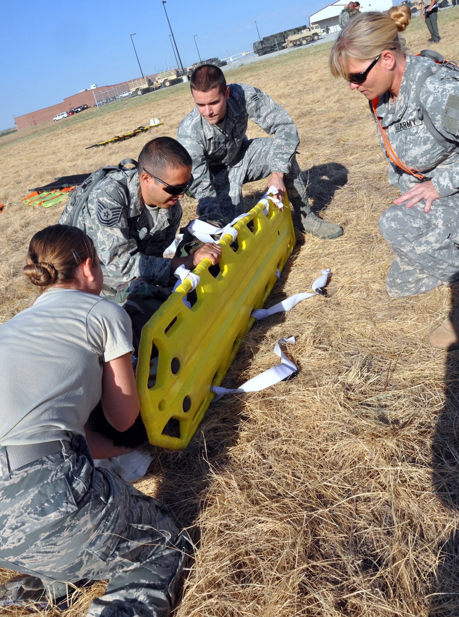 Air Force personnel from the 301st Medical Squadron work quickly to secure a simulated casualty and carry litter while observed by an Army medical evaluator during the second day of the joint Mass Casualty Exercise held at the Army Reserve Center, Fort Worth, September 10 and 11. Medical personnel from the 301st MDS, Army, Navy and civilian emergency responders participated in the exercise. The two-day exercise pulled together military and civilian units and emergency responders from around the area was designed to sharpen the operational skills and procedures of the organizations during joint operations.  (U.S. Air Force photo/Staff Sgt Chris Bolen)