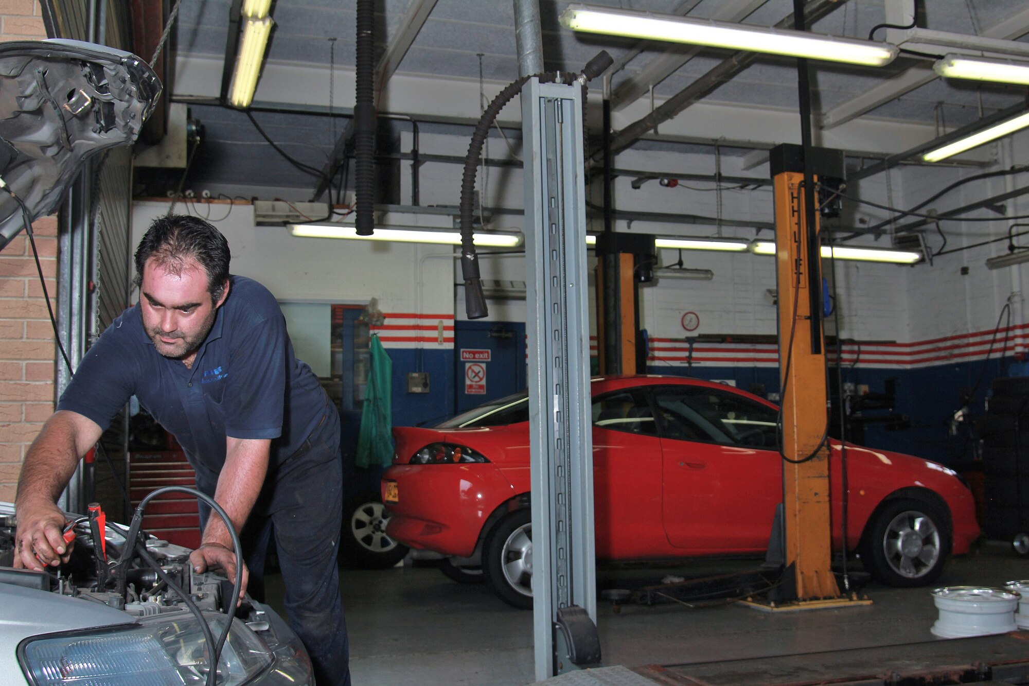 ROYAL AIR FORCE LAKENHEATH, England - Charles Marston, Army and Air Force Exchange Service auto mechanic, charges a battery at the RAF Lakenheath Car Care Center, Sept. 10, 2011. The car care center will close Oct. 1 and relocate its services to Building 650 shoppette, next to the bowling center.  (U.S. Air Force photo by Staff Sgt. Connor Estes)
