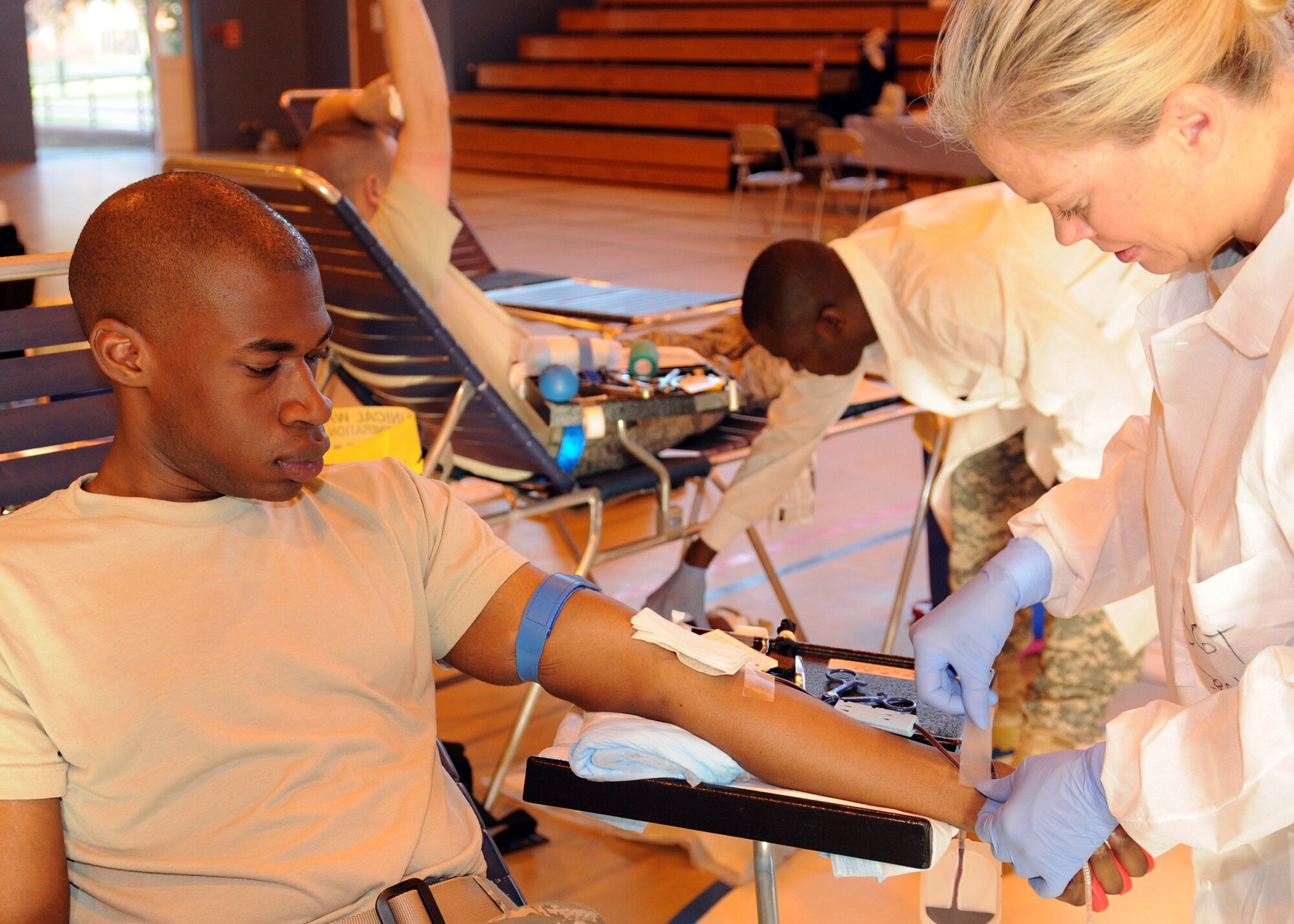RAF MILDENHALL, England -- Army Sgt.  Cheryl Decker, Landstuhl Regional Medical Center U.S. Army Europe Blood Donor Center medic, tapes a tube to the arm of blood donor, Airman 1st Class Joshua Morton, 100th Operations Group, during the Armed Services Blood Program Blood Drive here Sept. 13, 2011.  The drive is accepting donations until 5 p.m. Sept. 13. It continues Sept. 14 at the RAF Lakenheath main gym from 8 a.m. to 5 p.m. and walk-ins are welcome.  (U.S. Air Force photo by Staff Sgt. Tabitha M. Lee) 