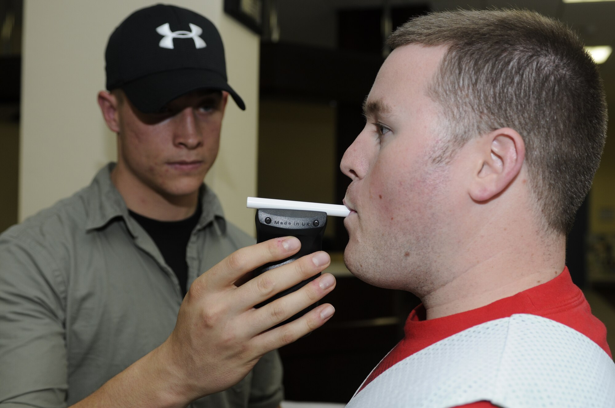 Senior Airman Jonathon Crist, 52nd Security Forces Squadron, left, gives Staff Sgt. Anthony Ross, 52nd Aircraft Maintenance Squadron, a breathalyzer test during an alcohol awareness class Sept. 10 at the Brick House. This class gave Airmen a firsthand understanding of how alcohol affects their abilities. They also learned how to accurately count how much alcohol they consume. Airmen who participated in the class drank one alcoholic drink an hour, not to exceed five, and participated in exercises testing their cognitive thinking, reaction time and balance. Airmen also participated as designated drivers for those drinking. (U.S. Air Force photo/ Senior Airman Natasha Stannard)