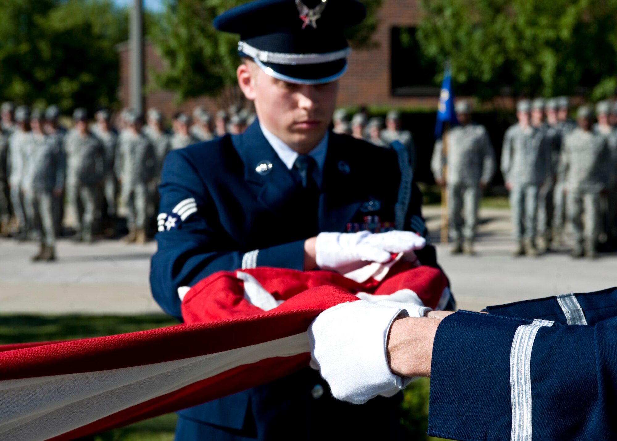 Senior Airman David Carter, 28th Maintenance Squadron aerospace ground equipment journeyman, and Staff Sgt. Thomas Waters, Air Force Financial Services Center military pay technician, fold the flag during POW/MIA and 9/11 Remembrance Retreat Ceremony on Ellsworth Air Force Base, S.D., Sept. 9, 2011. This ceremony was held to pay homage to those lost in wartime and in the tragic events of Sept. 11, 2001. (U.S. Air Force photo by Airman Alystria Maurer/Released)