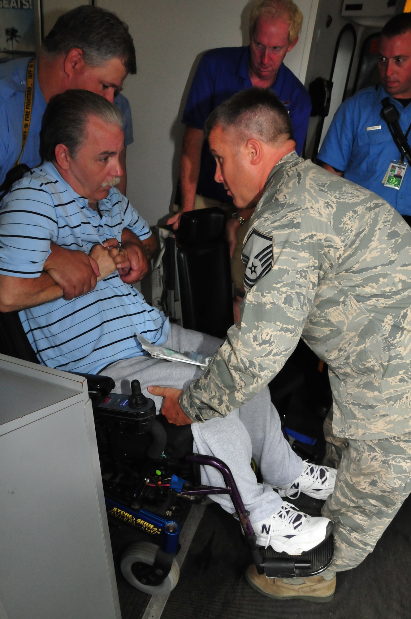 Members of the 171st Air Refueling Wing volunteer to help athletes who participated in the National Veterans Wheelchair games board their planes as they departed Pittsburgh International Airport on Sunday, August 7, 2011. MSgt Richardson helps in lifting veterans to the special aisle chair to load the plane.