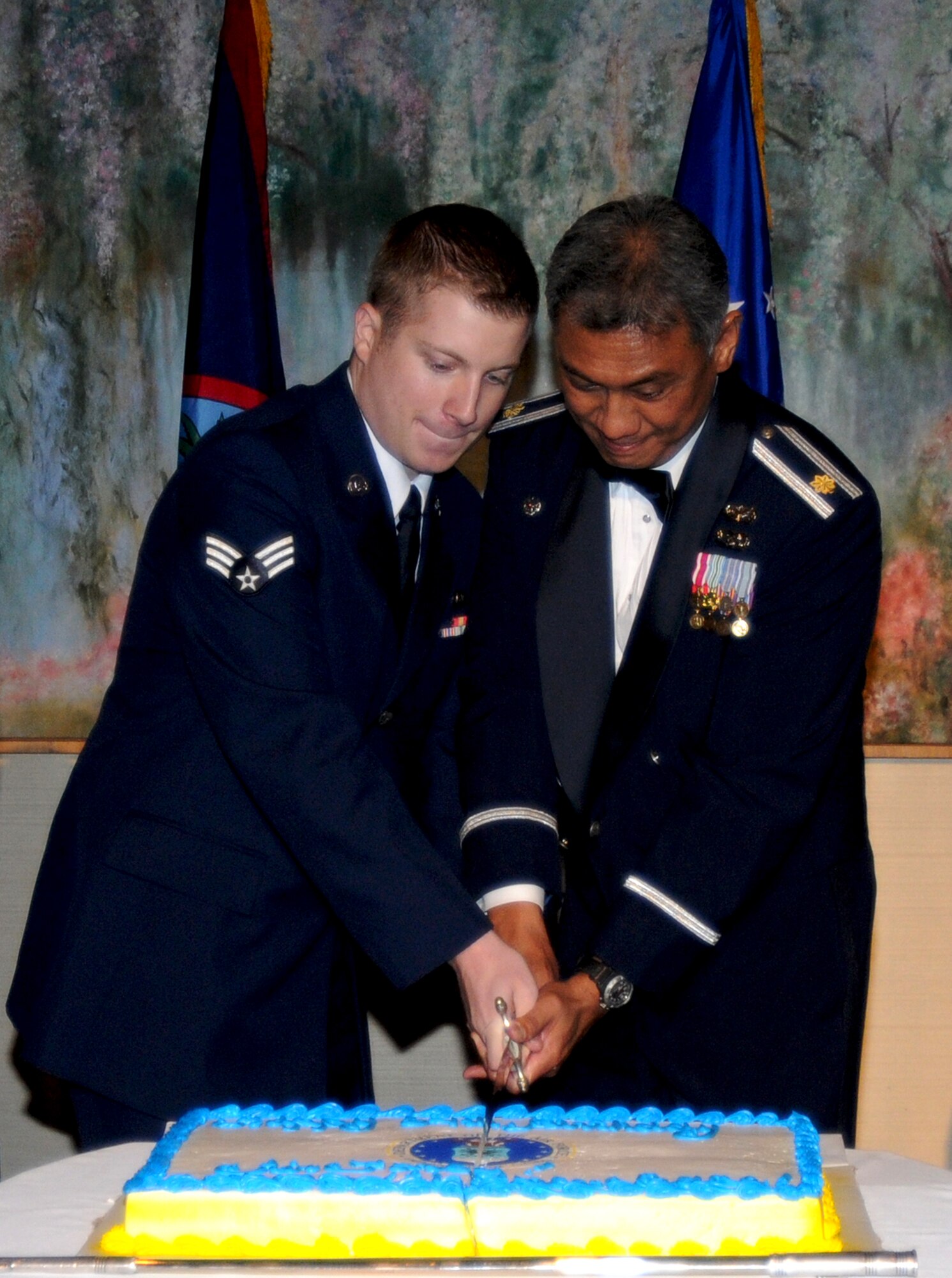 TUMON, Guam—Two members from Andersen cut the cake during the 64th annual Air Force Ball held in Tumon, Sep. 9. It is tradition that the youngest and oldest Airman, by time in service, cut the cake together during the ceremony.  (U.S. Air Force photo by Senior Airman Carlin Leslie/Released)
