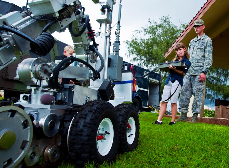 ANDERSEN AIR FORCE BASE, Guam—Amathyst Segerlund, an Andersen dependent, remotely controls the explosive ordinance and disposal robot as her dad, Senior Airman Steven Segerlund, watches during an emergency management showcase here, Sep. 8. The showcase was part of Andersen taking part in National Preparedness Month. (U.S. Air Force photo by Senior Airman Benjamin Wiseman/Released)