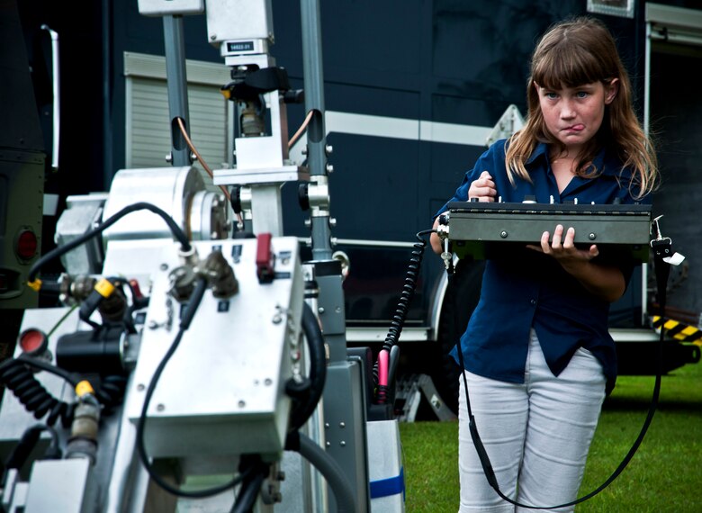 ANDERSEN AIR FORCE BASE, Guam—Amathyst Segerlund, daughter of Senior Airman Steven Segerlund and his wife, Danielle, remotely controls the explosive ordinance and disposal robot during an emergency management showcase here, Sep. 8. The showcase was part of Andersen taking part in National Preparedness Month. (U.S. Air Force photo by Senior Airman Benjamin Wiseman/Released